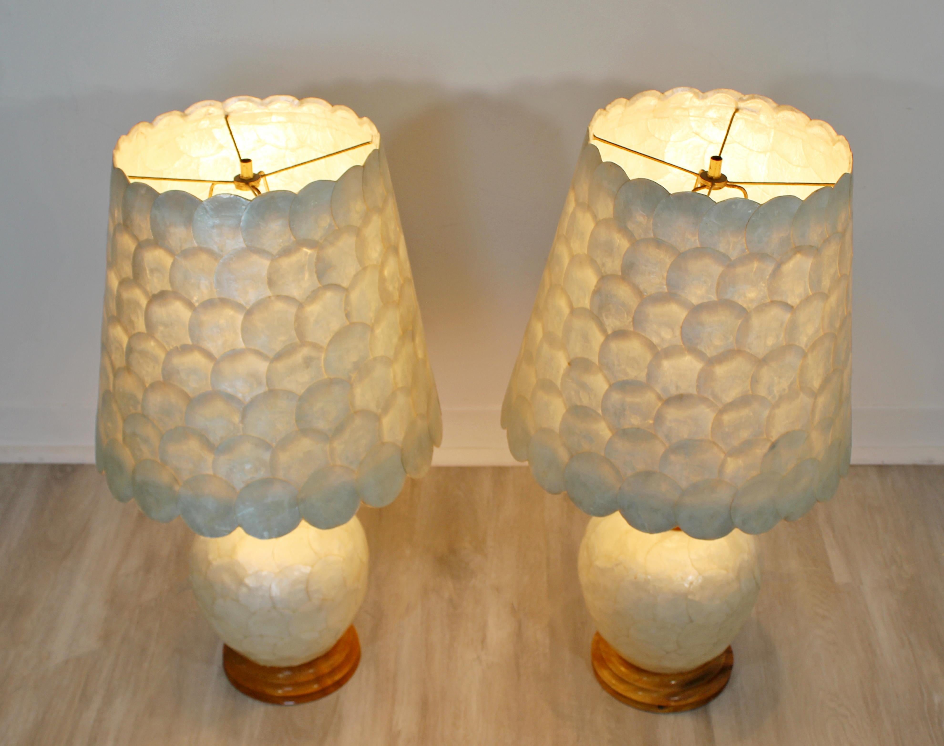 For your consideration is a shimmering pair of Capiz shell table lamps, with brass details and wood bases, circa 1970s. In excellent condition. The dimensions are 12