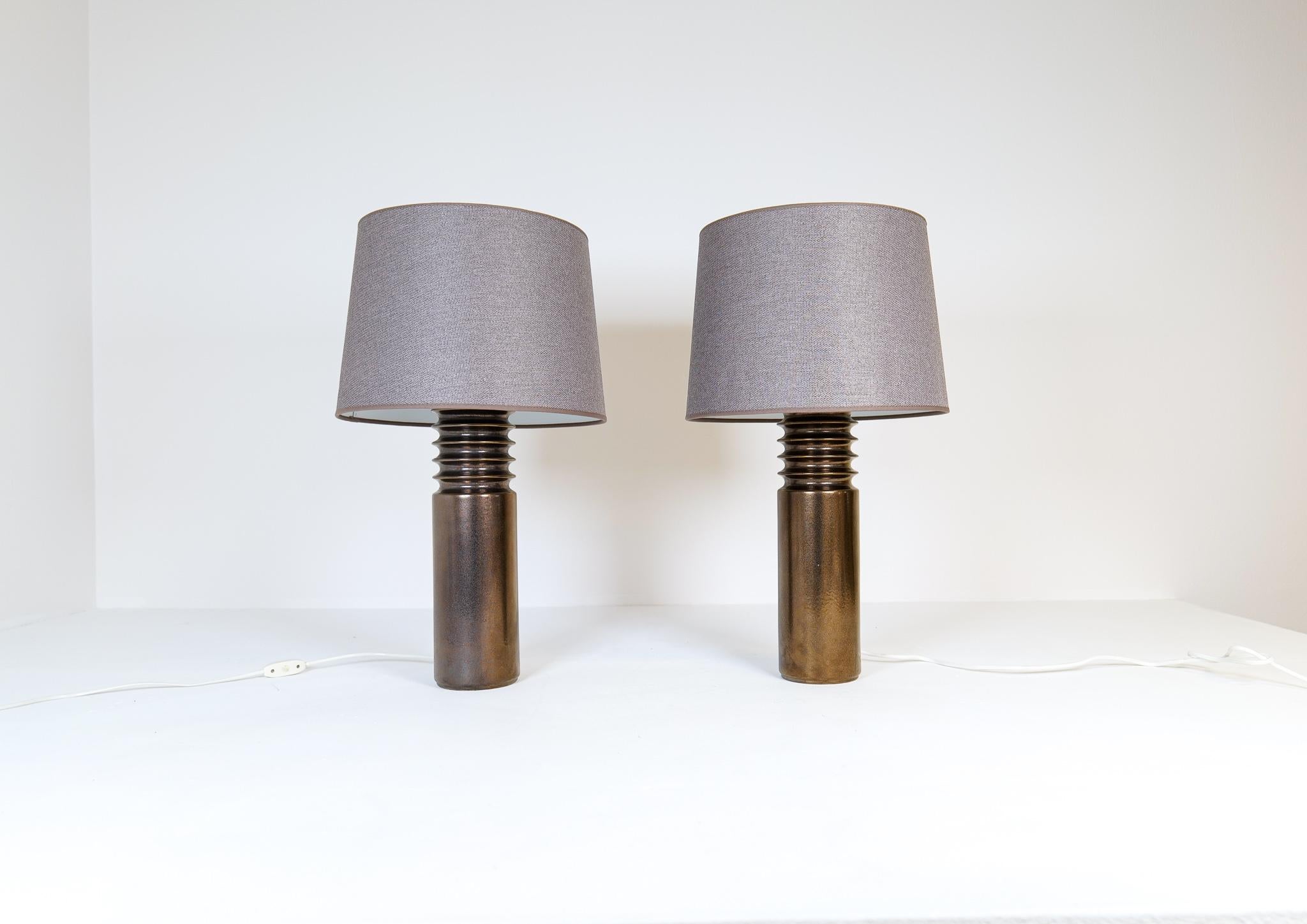 These Mid-Century Modern table lamps were manufactured in Sweden for Luxus. 
The lamps made in a bronze/gold colored ceramic with all new quality shades made in Sweden. 
Sculptural and typical look of the early 1970s Sweden on these table
