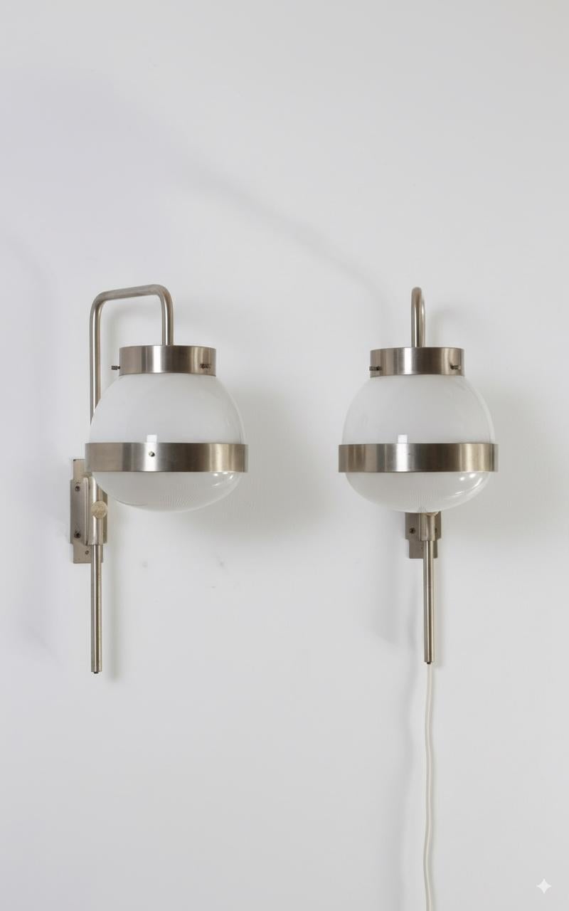Este par de apliques Delta fue diseñado por el italiano Sergio Mazza para Artemide en la década de 1960.
Este modelo de gran éxito ganó el prestigioso premio Compasso d'Oro en 1960. Estas lámparas de pared regulables en altura presentan una estética