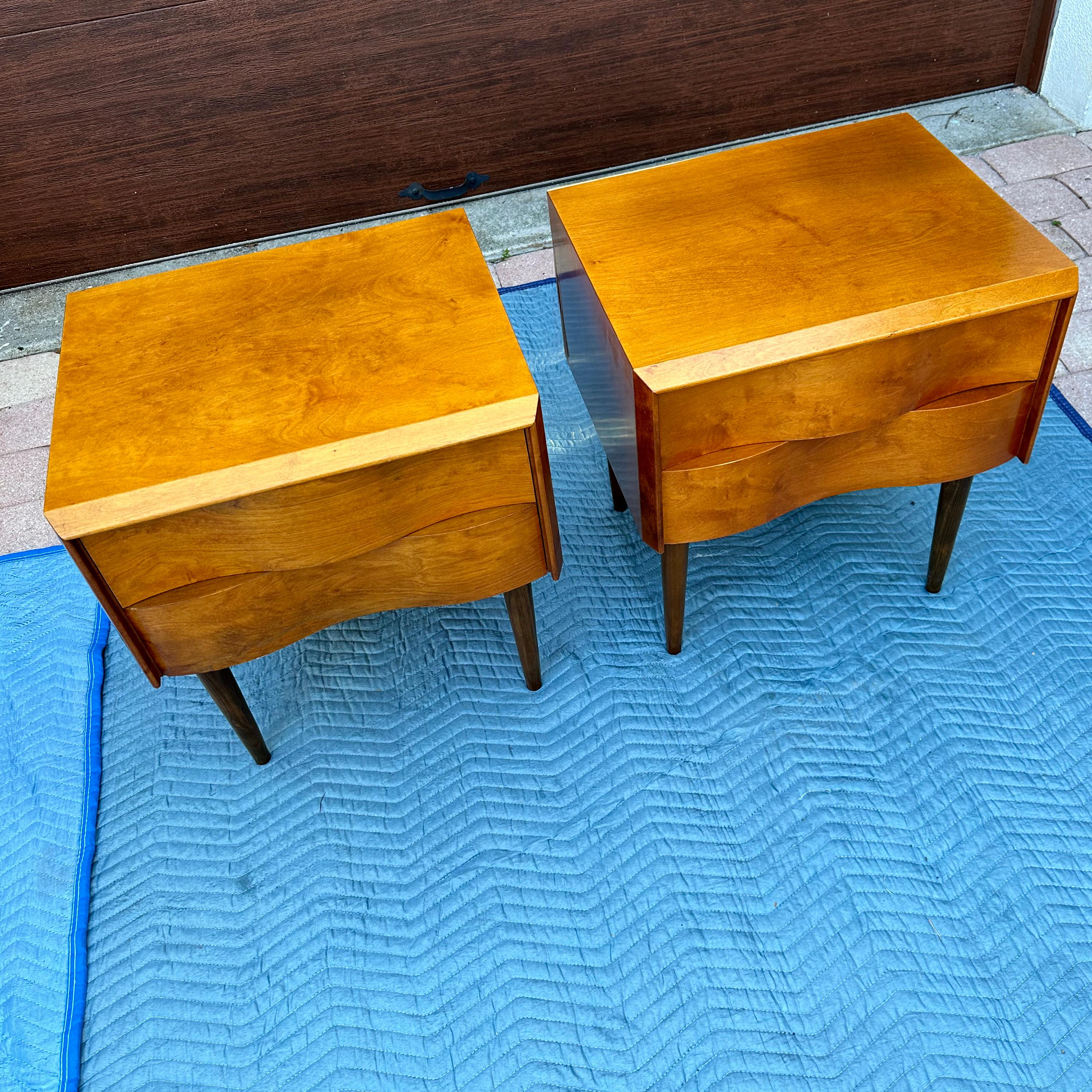 Mid Century Modern wavey front 2 drawer, pair of nightstands.  Gorgeous birch wood sculptural design atop 4 long dowel legs.  Designed by Edmond Spence and manufactured in Sweden. These would complement any style decor. 