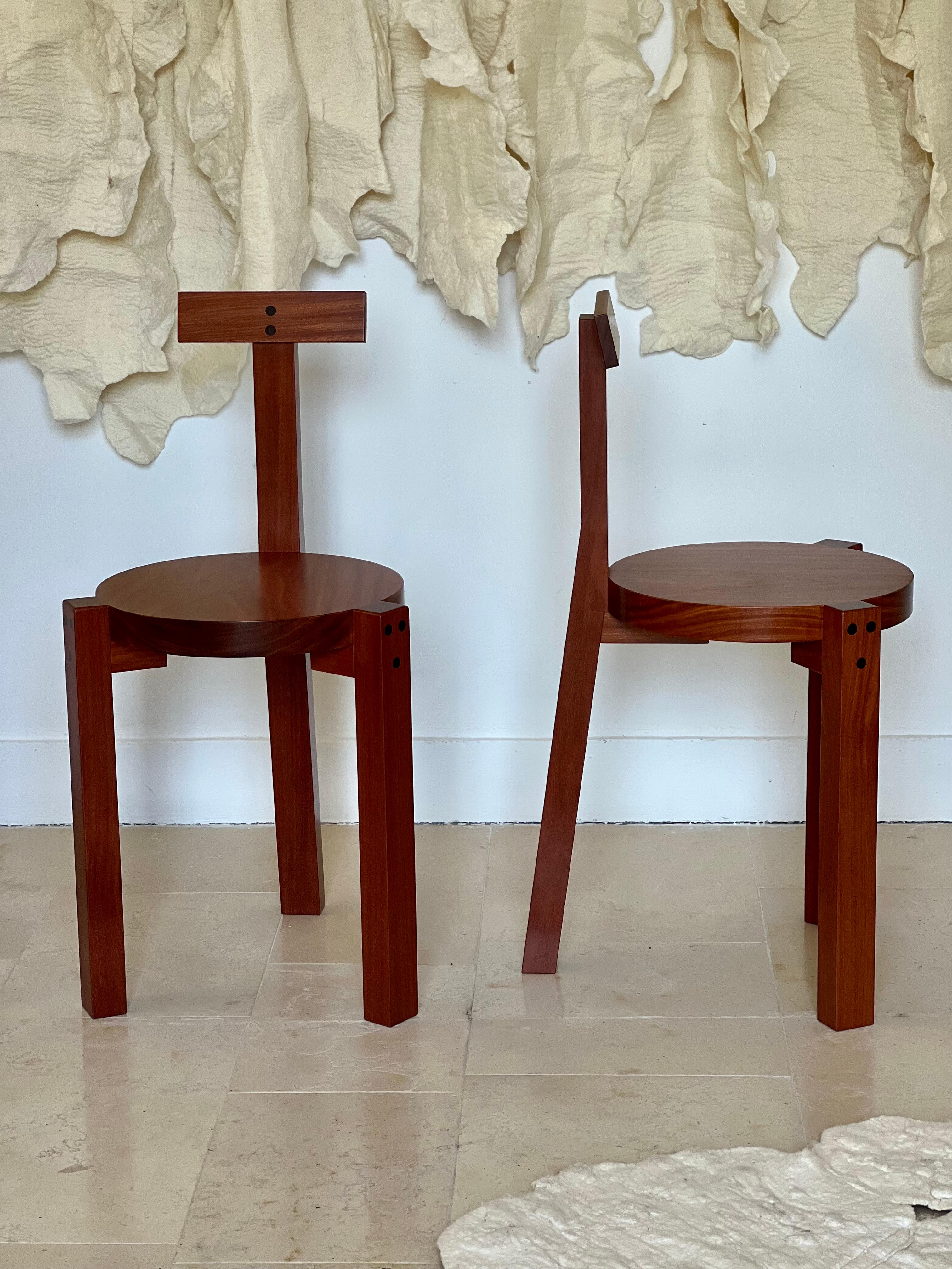 The Girafa chair, designed by Italian-Brazilian architect Lina Bo Bardi in 1986, is a distinctive piece of furniture that features a tall, slender backrest resembling a giraffe's neck. The chair is made from wood, and is supported by a tripod