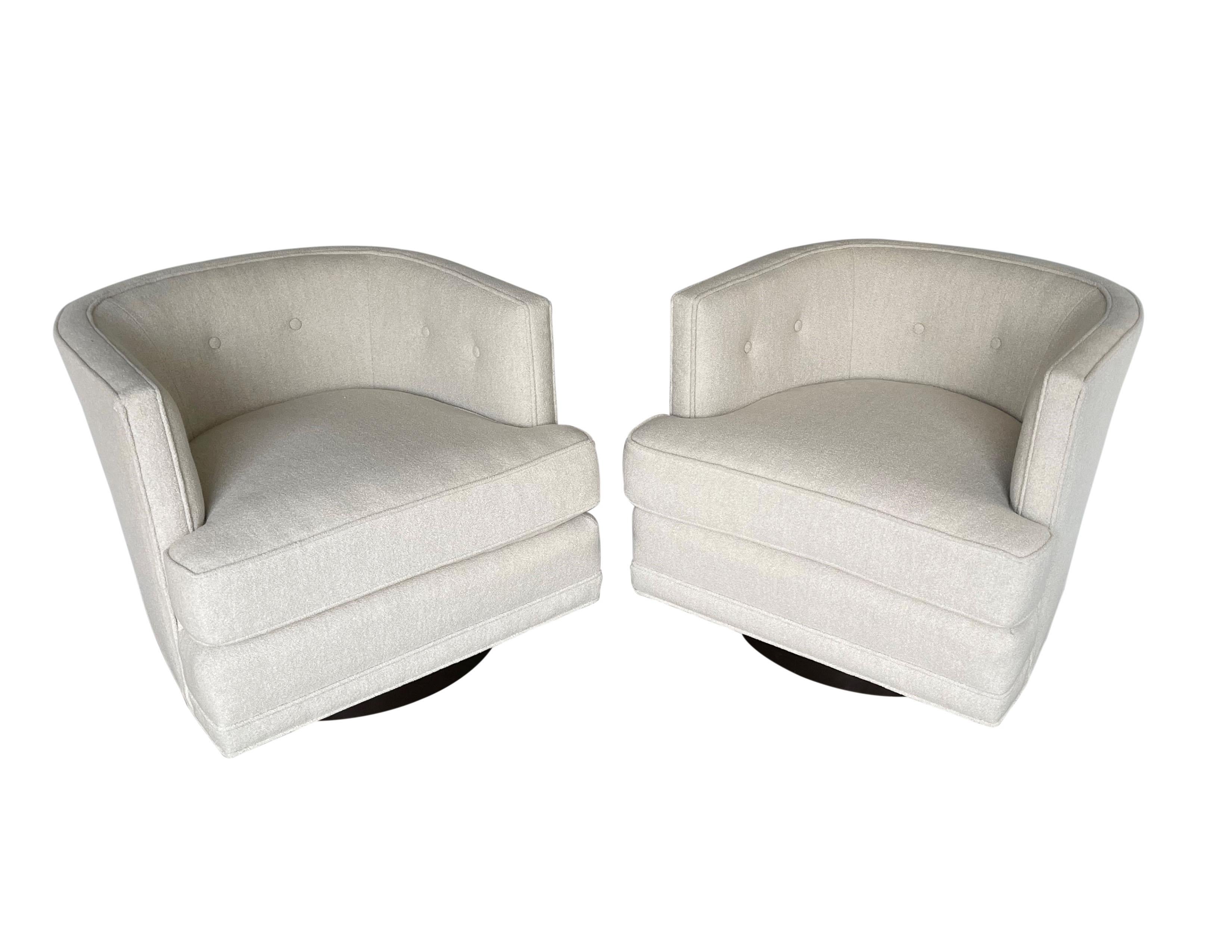 Retro glamour meets modern comfort pair of swivel lounge chairs attributed to Harvey Probber. Pristinely tailored chairs feature a barreled tufted back creating a cozy embrace, oversized detached plush cushion seat and flat front aprons, freshly