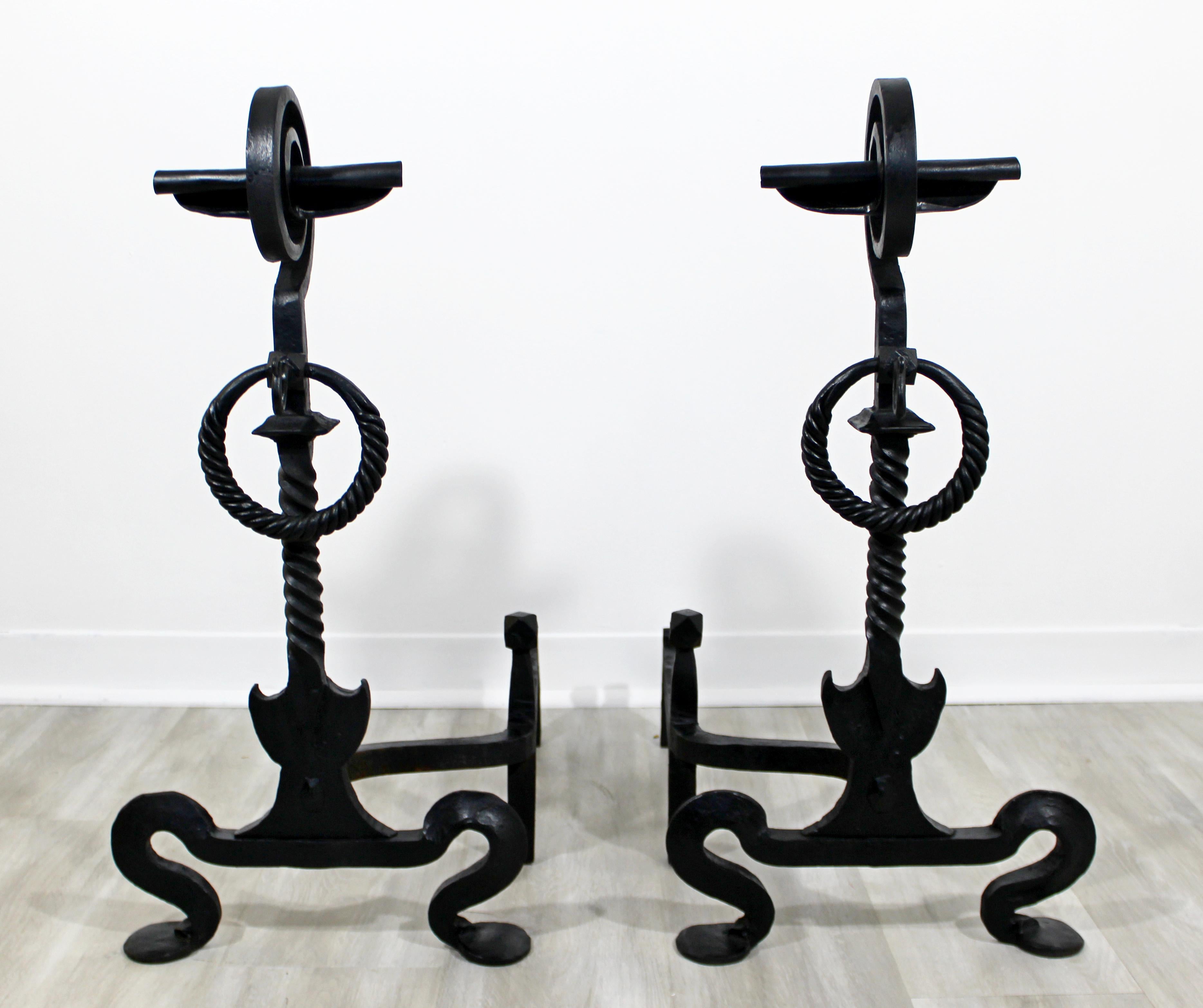 For your consideration is a stunning pair of intricate and heavy blacksmith hand forged andirons, circa 1960s. In excellent condition. The dimensions of each are 14