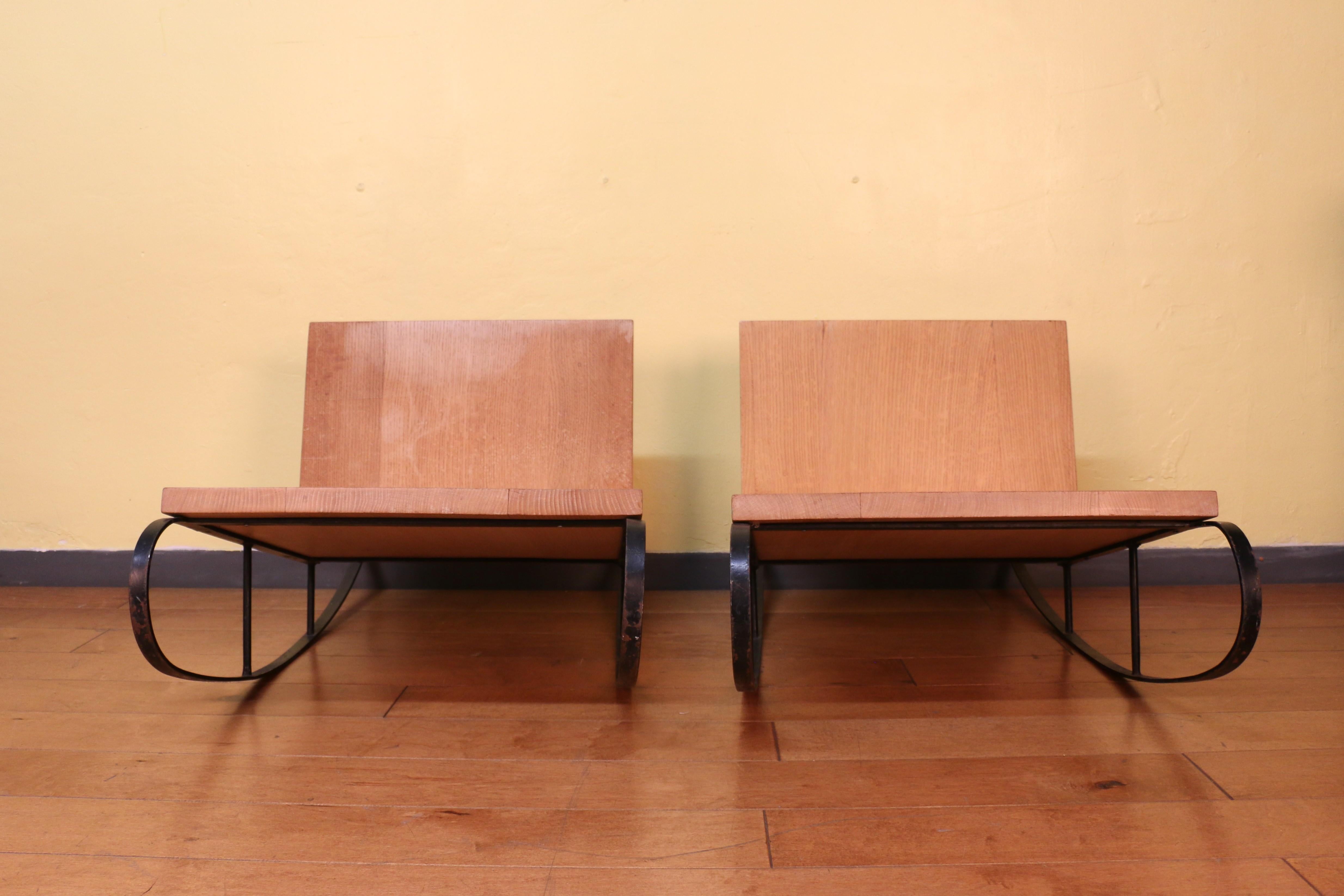 Splendida coppia di sedie a dondolo dal design moderno e minimalista di ispirazione francese. Presenta una seduta e uno schienale in legno di quercia bianca, sostenuti da una struttura in metallo nero che costituisce la base a dondolo. Il design è