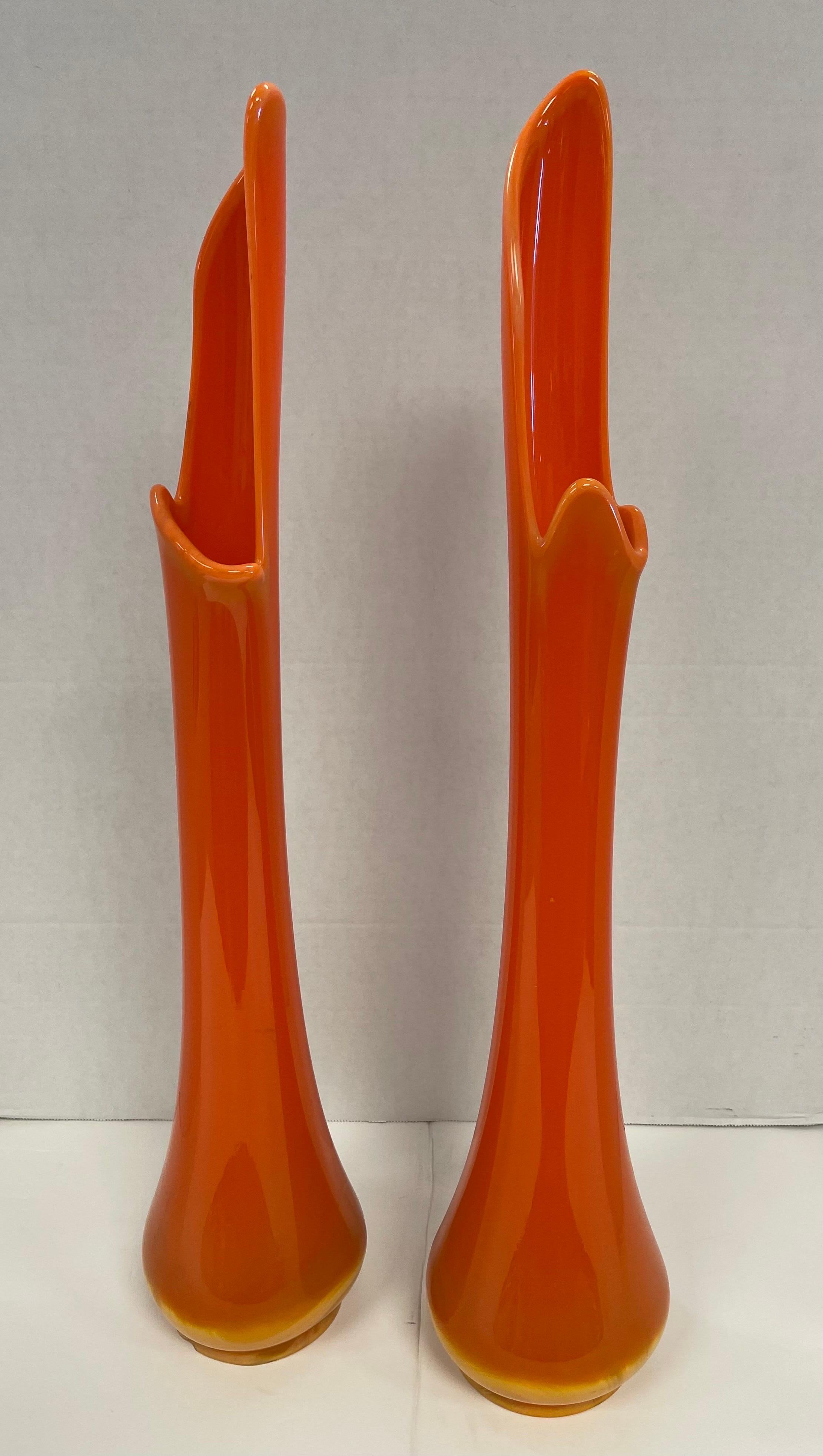 Magnificent matching pair of Hermes orange colored swung slag glass vases. No hallmarks at bottom. Measurements are below and note one is .5 inches shorter than the other. Vibrant orange color down to the bottom where it becomes lighter orange only