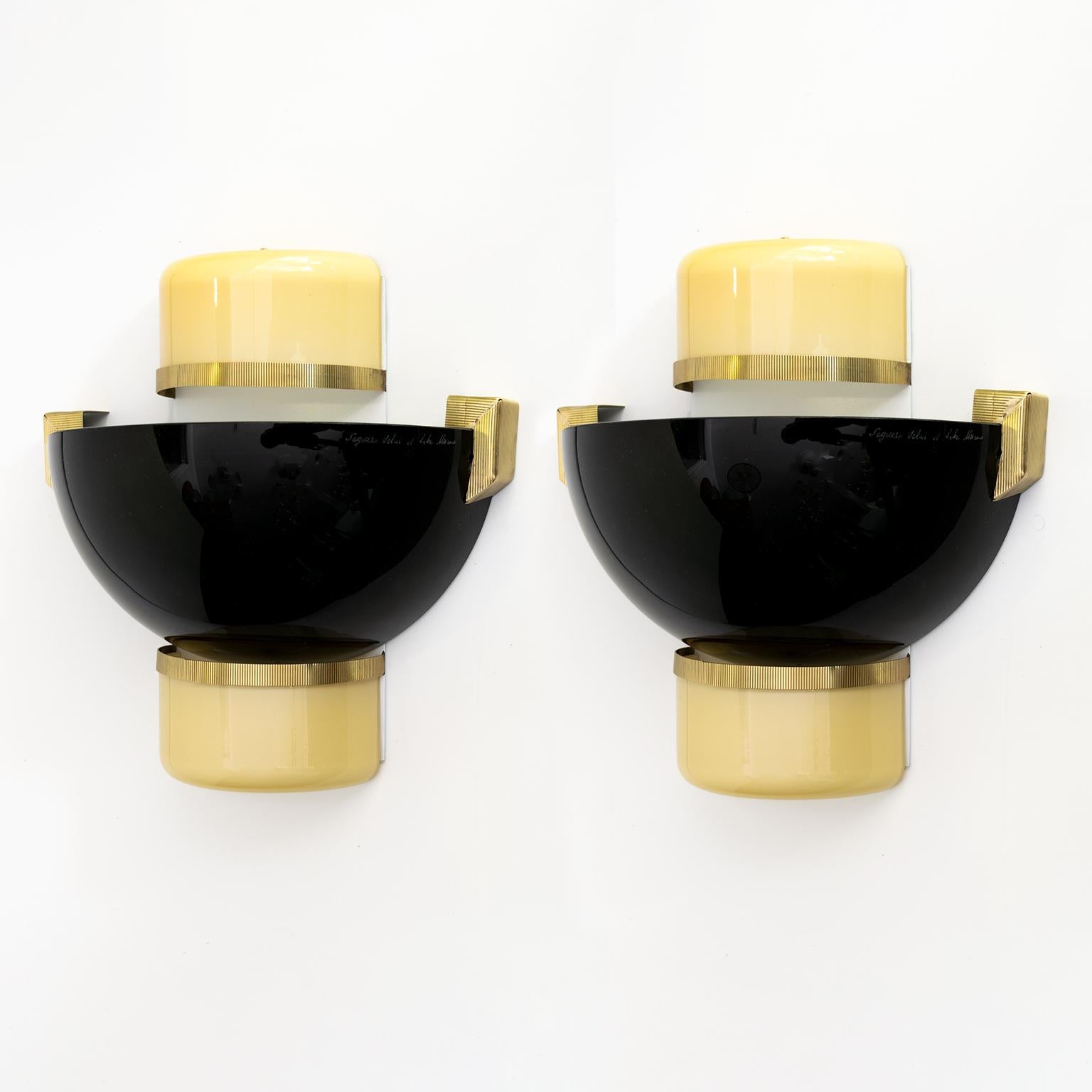 A pair of Mid-Century Modern Seguso Vetri d'Arte black and gold color glass sconces with detail in polished brass. The sconces have been fully restored and each sconce has been newly wired with 2 candelabra bulb sockets. Made in Murano, Italy circa
