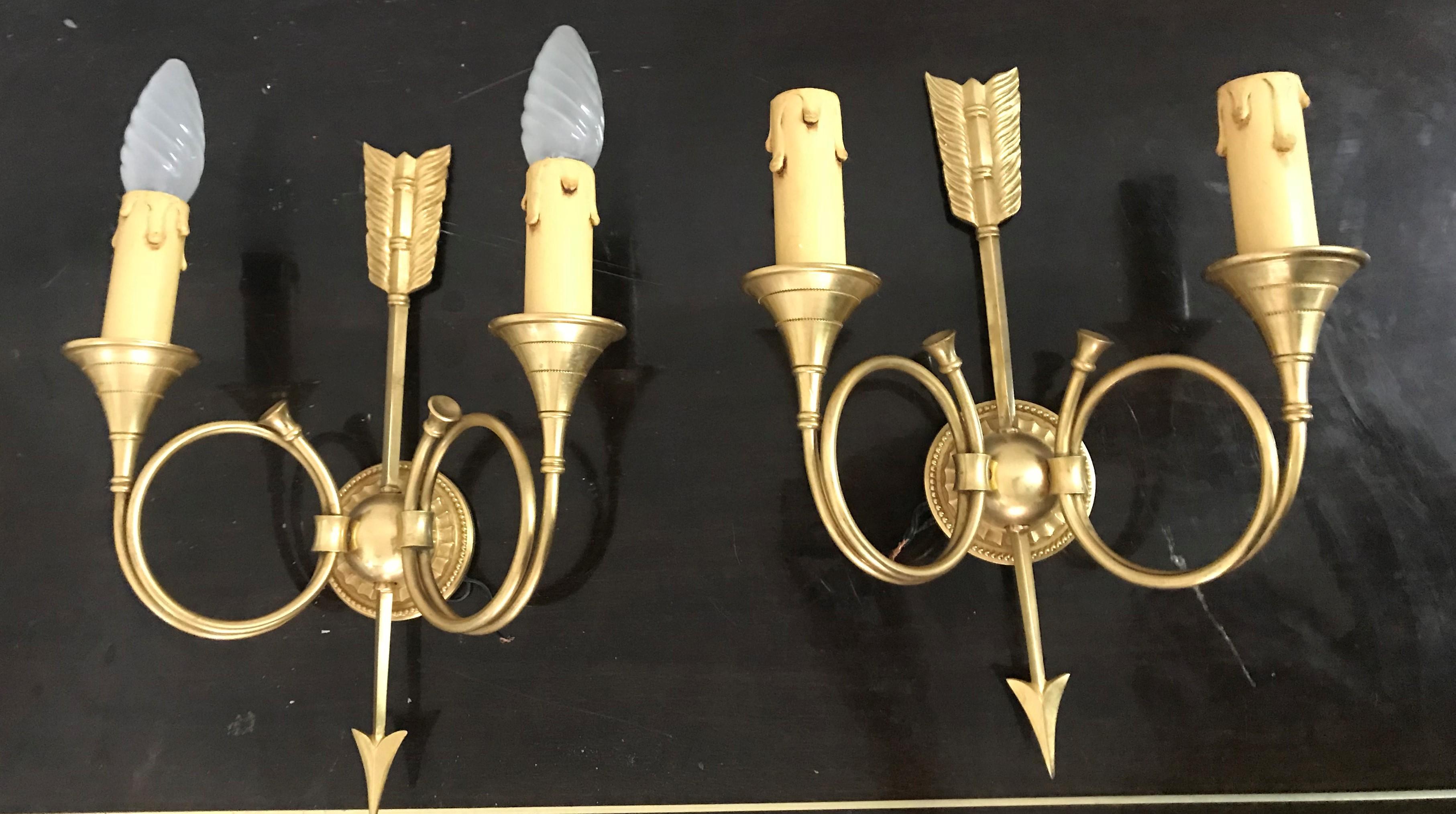 Paar zweiflammige Leuchter in Form eines Pfeils und eines Horns aus Bronze, beide mit der Prägung 