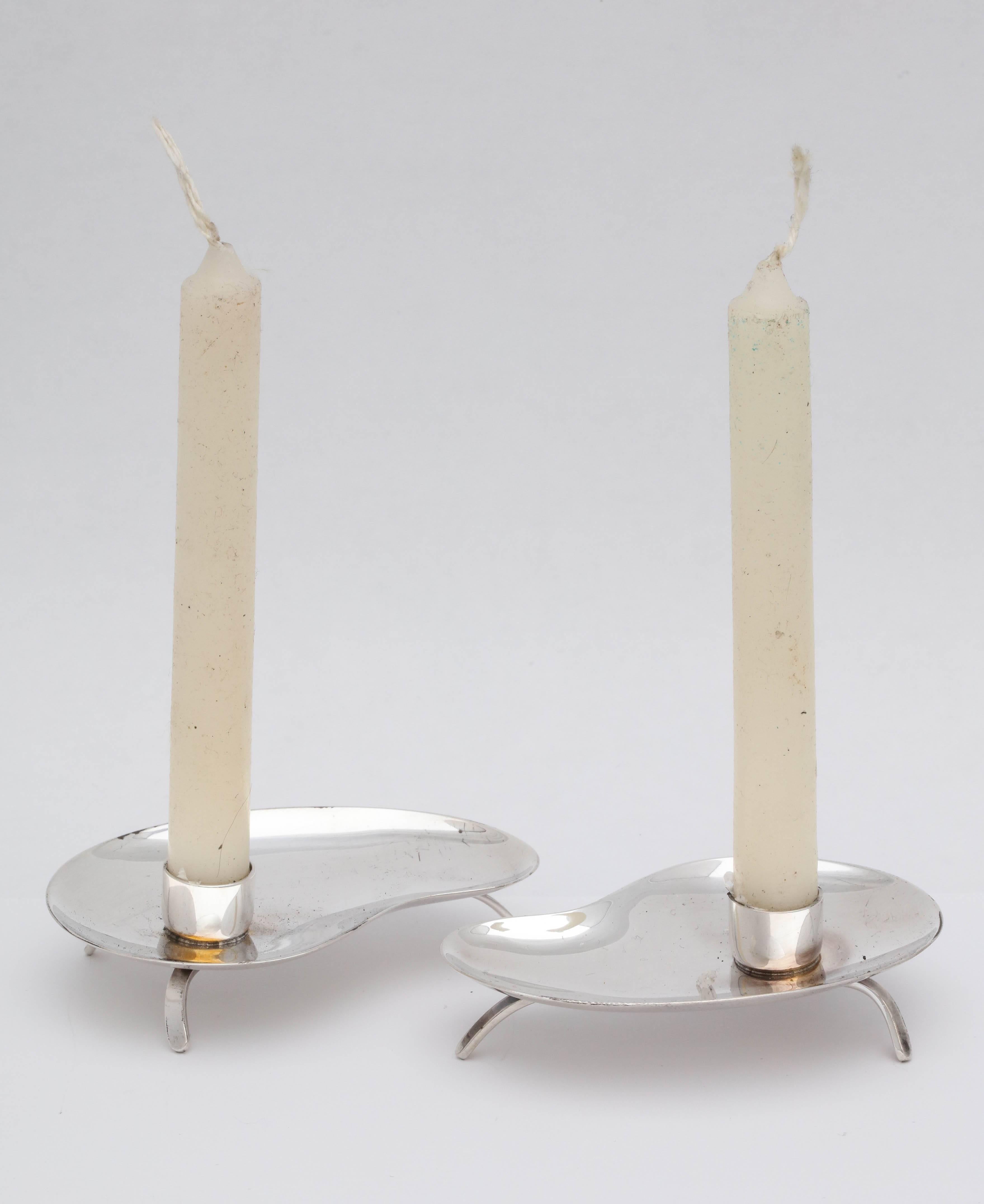 Mid-Century Modern, pair of sterling silver, footed candlesticks, Denmark, circa 1950s, Hugo Grun and Co. - makers. Each measures 3 inches wide (at widest point) x 2 inches deep (at deepest point) x 1 inch high at highest point. Pair weighs 1.740
