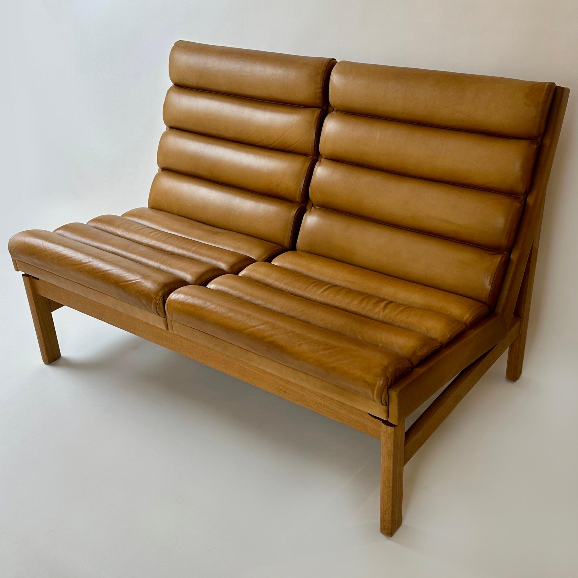 Ti presentiamo una rara coppia di divani da salotto in pelle a righe color cognac, prodotti da JOC Vetlanda nel 1969. Questi divani estremamente confortevoli sono un classico senza tempo, con una struttura di alta qualità che durerà per anni. La