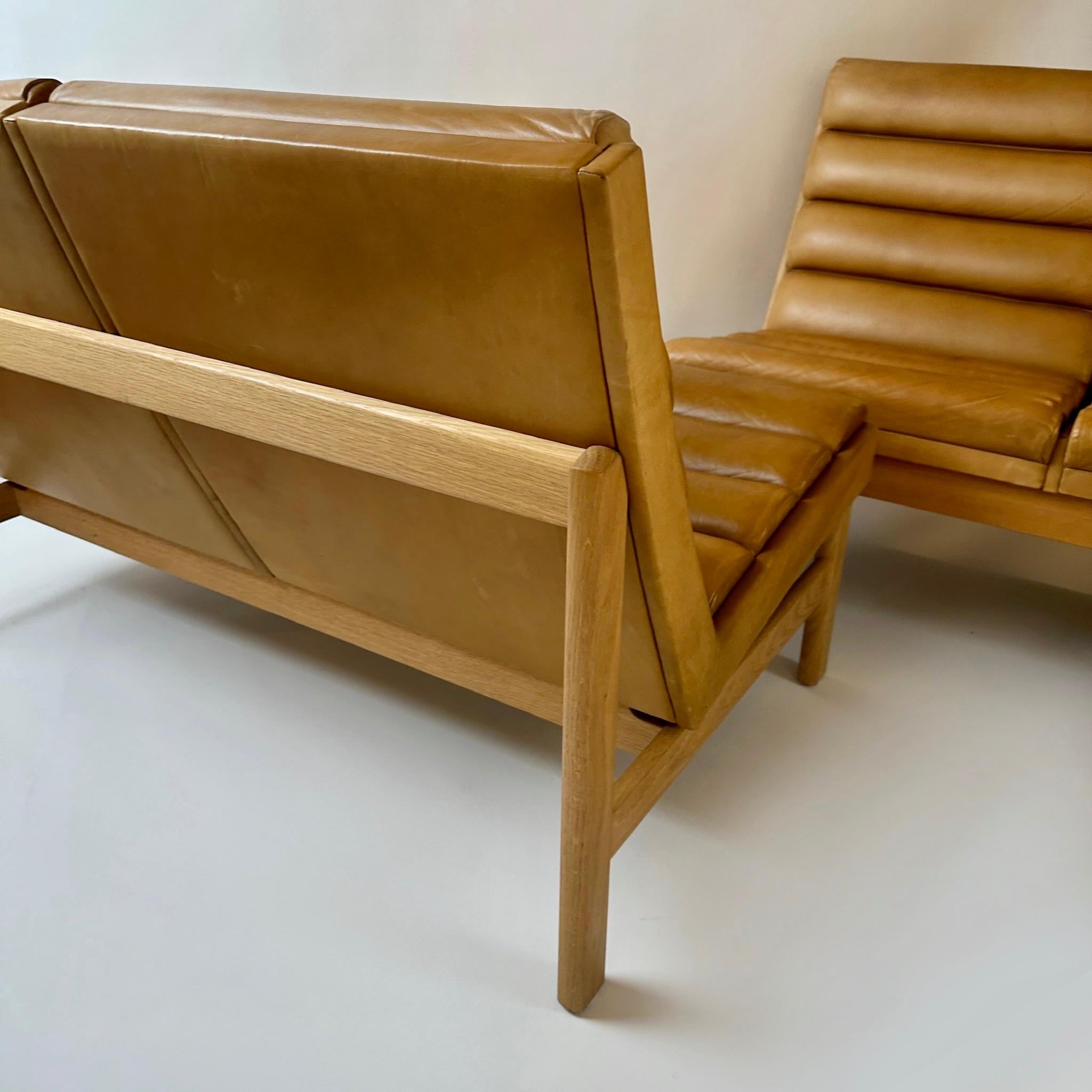 Metà XX secolo Coppia di divani svedesi in Oak e pelle color cognac di K. E. Ekselius, metà secolo. in vendita