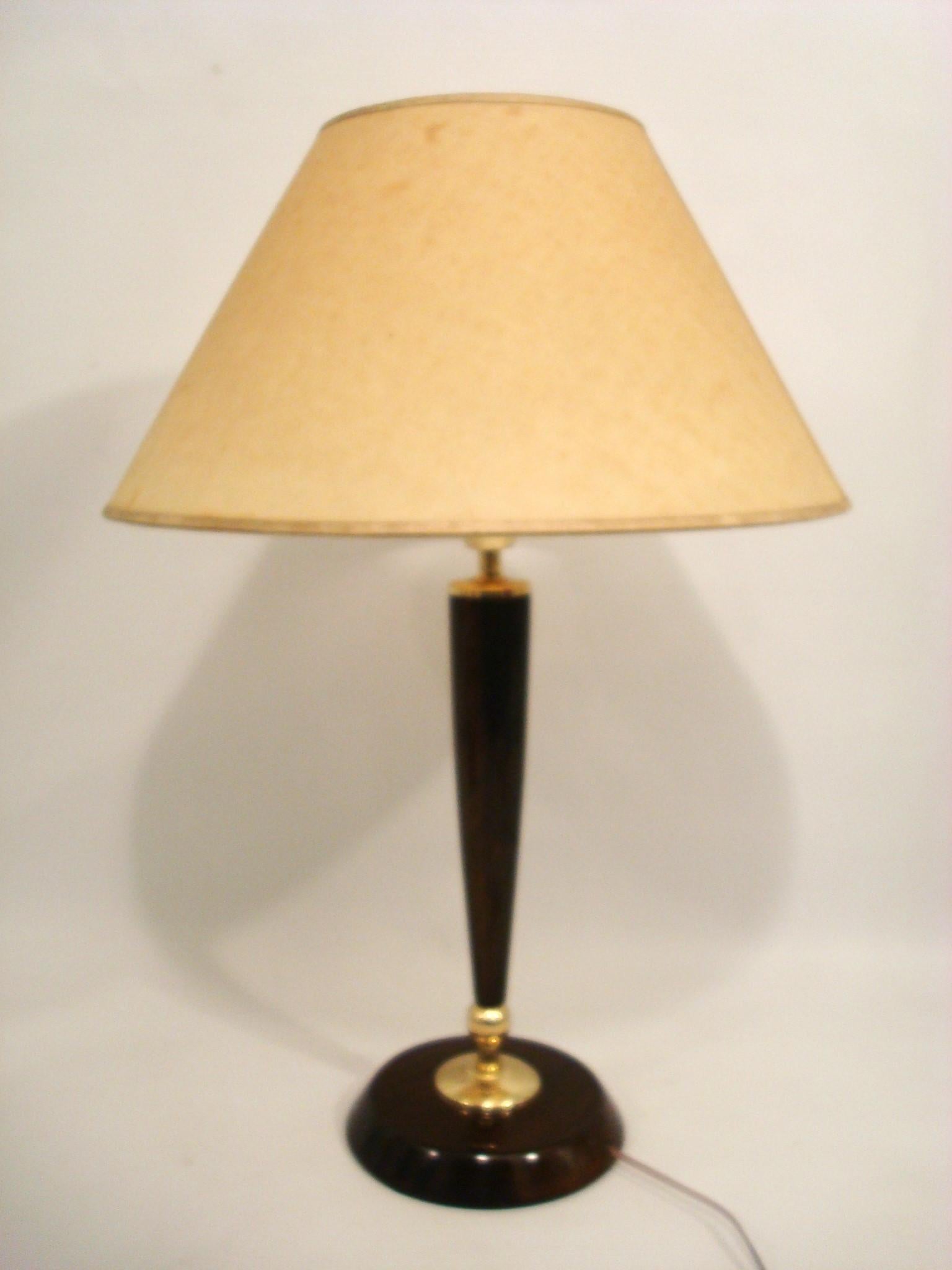 Cette paire sculpturale de lampes de table incarne l'élégance raffinée et l'artisanat associés au design scandinave du milieu du siècle. Fabriquées dans les années 1950, ces lampes sont dotées d'un corps mince et conique en teck et en laiton, créant