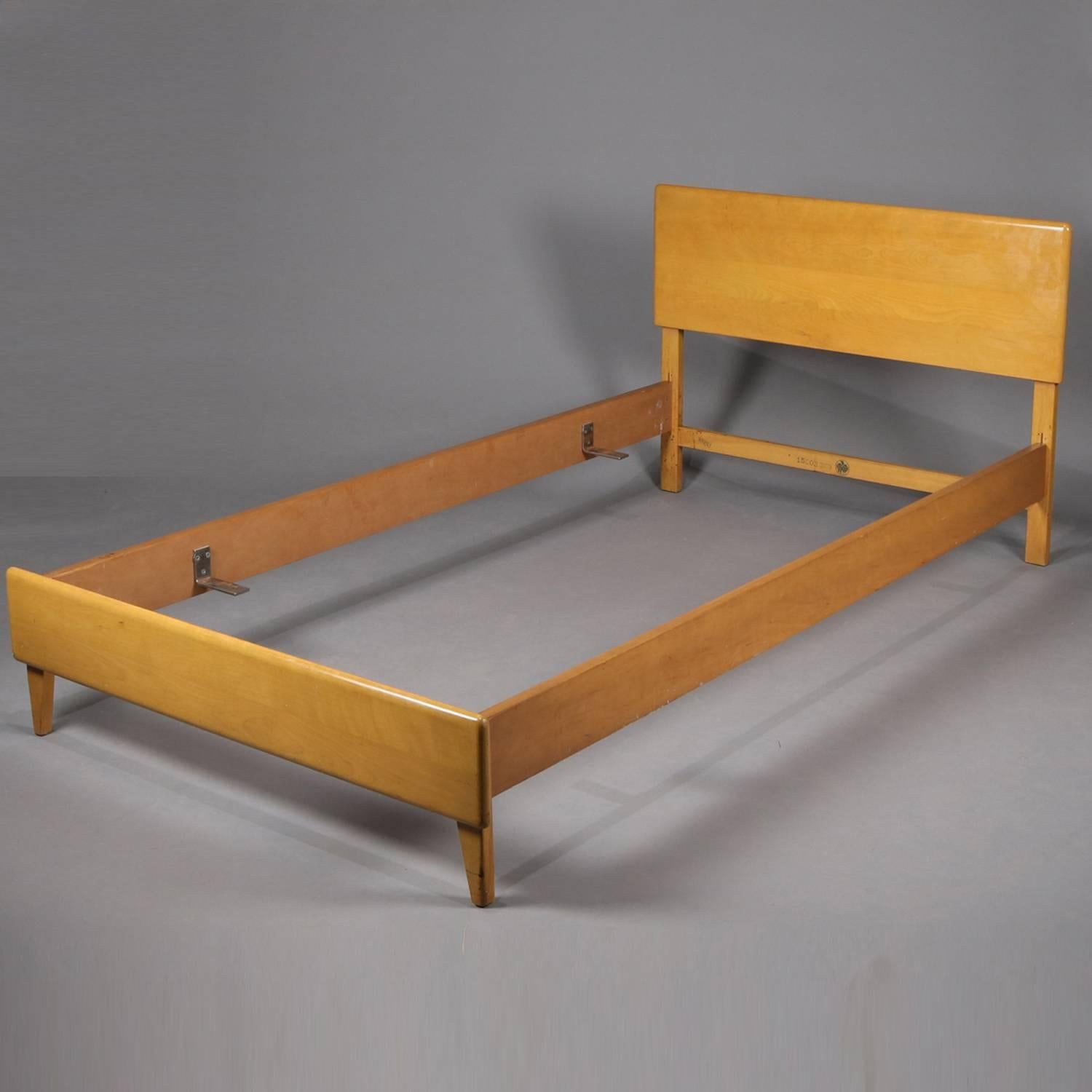 Pair of Mid-Century Modern Heywood Wakefield twin bed frames in wheat finish, maker stamp on rail, mid-20th century.

Measures: 31