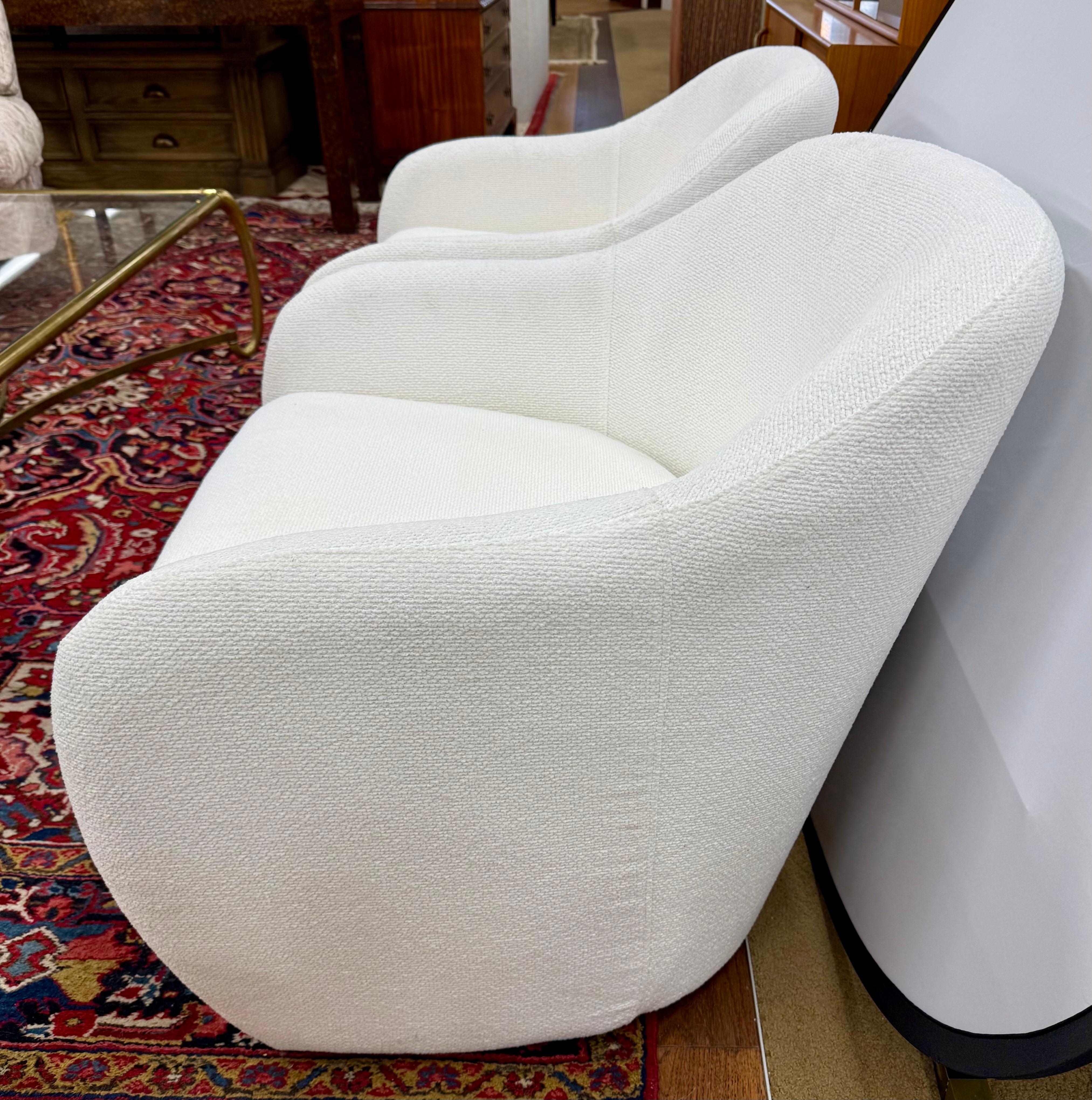 Striking the perfect balance between sculptural form and cozy comfort, this pair of Mid-Century Modern style club chairs brings timeless sophistication to any interior. Featuring bold, continuous curves and a low-slung profile, these chairs are as