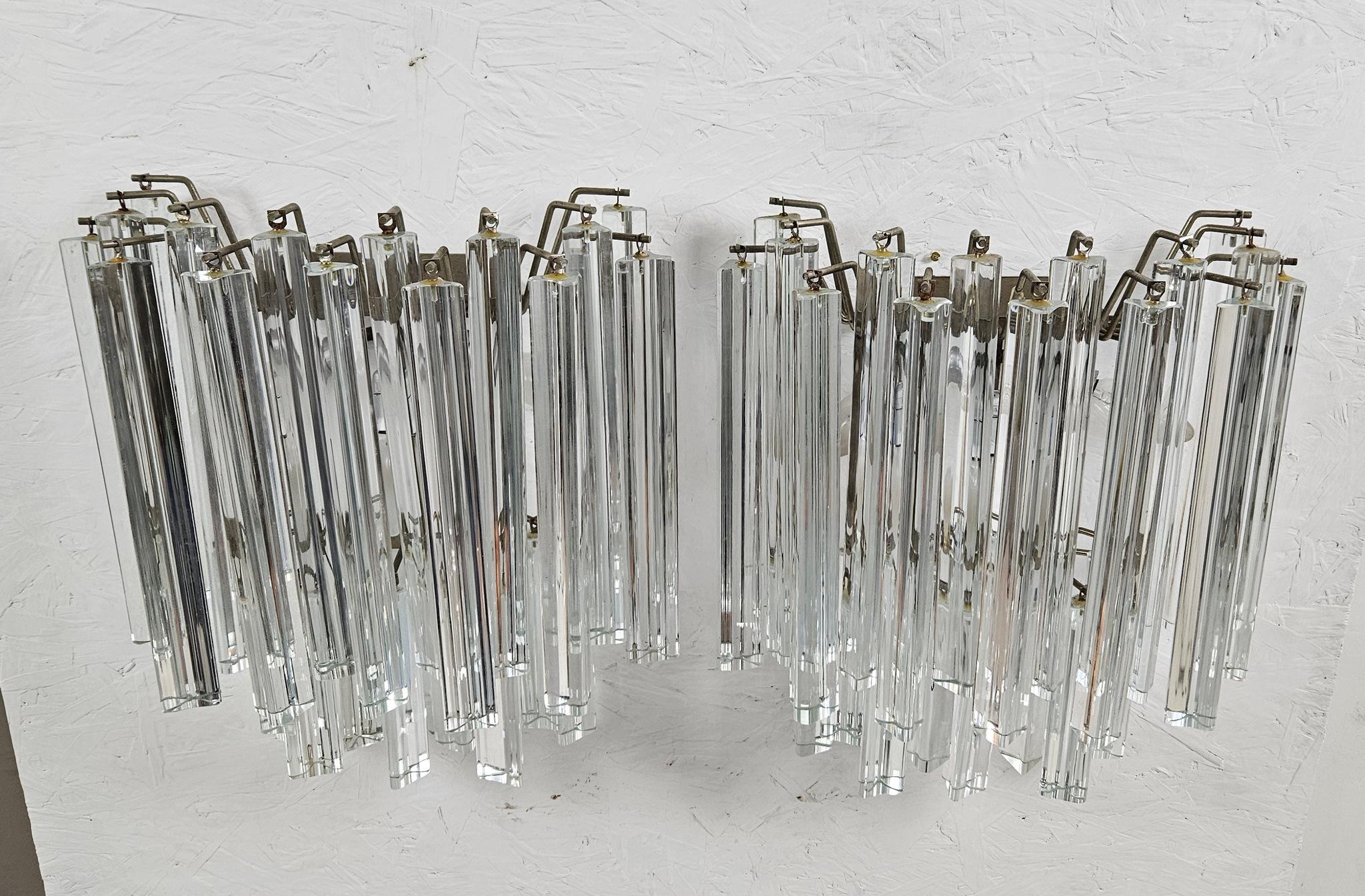 Un par de apliques clásicos Venini fabricados en Murano. Presenta dos hileras de tallos triangulares de cristal macizo transparente que reflejan la luz de forma maravillosa. Producciones originales de los años 1960-1970. No son copias. 