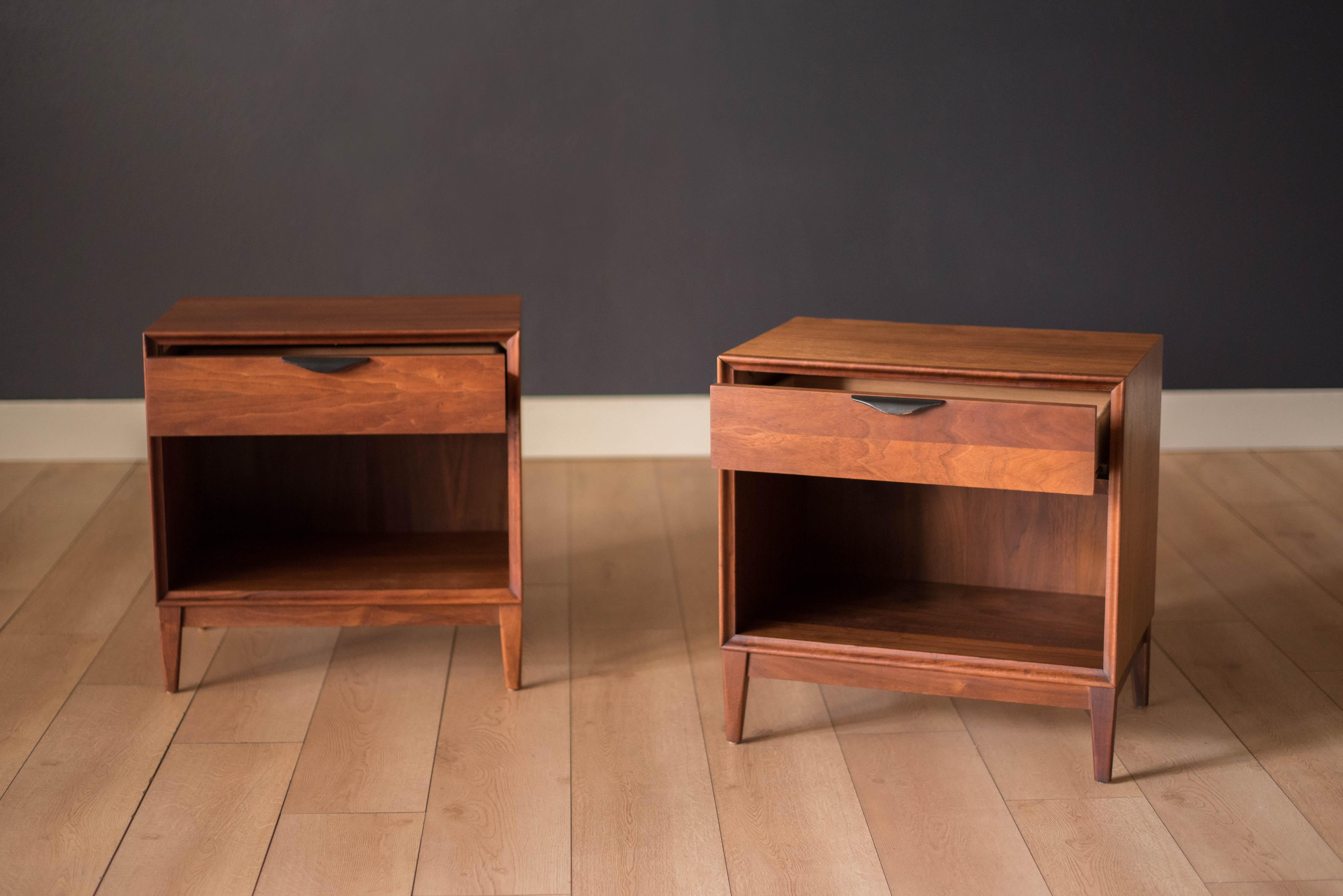 Midcentury pair of nightstands in walnut manufactured by Dillingham, circa 1960s. This set includes one storage drawer accessorized with an ebonized sculpted handle and open cabinet space below.


 
