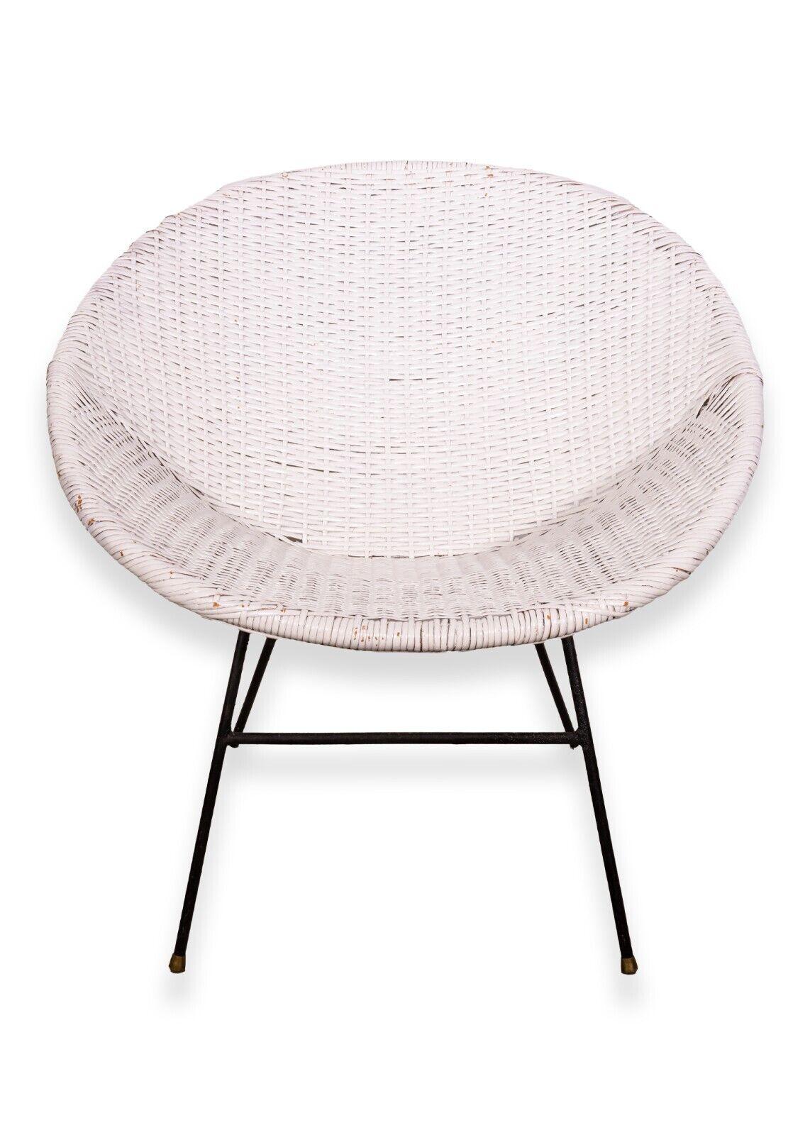 A Mid-Century Modern pair of scoop rattan chairs. A very chic set of chairs. These chairs are made of a woven wood rattan with a metal base. These chairs sit very comfortably firm thanks to their iconic bucket design. They are finished in a white