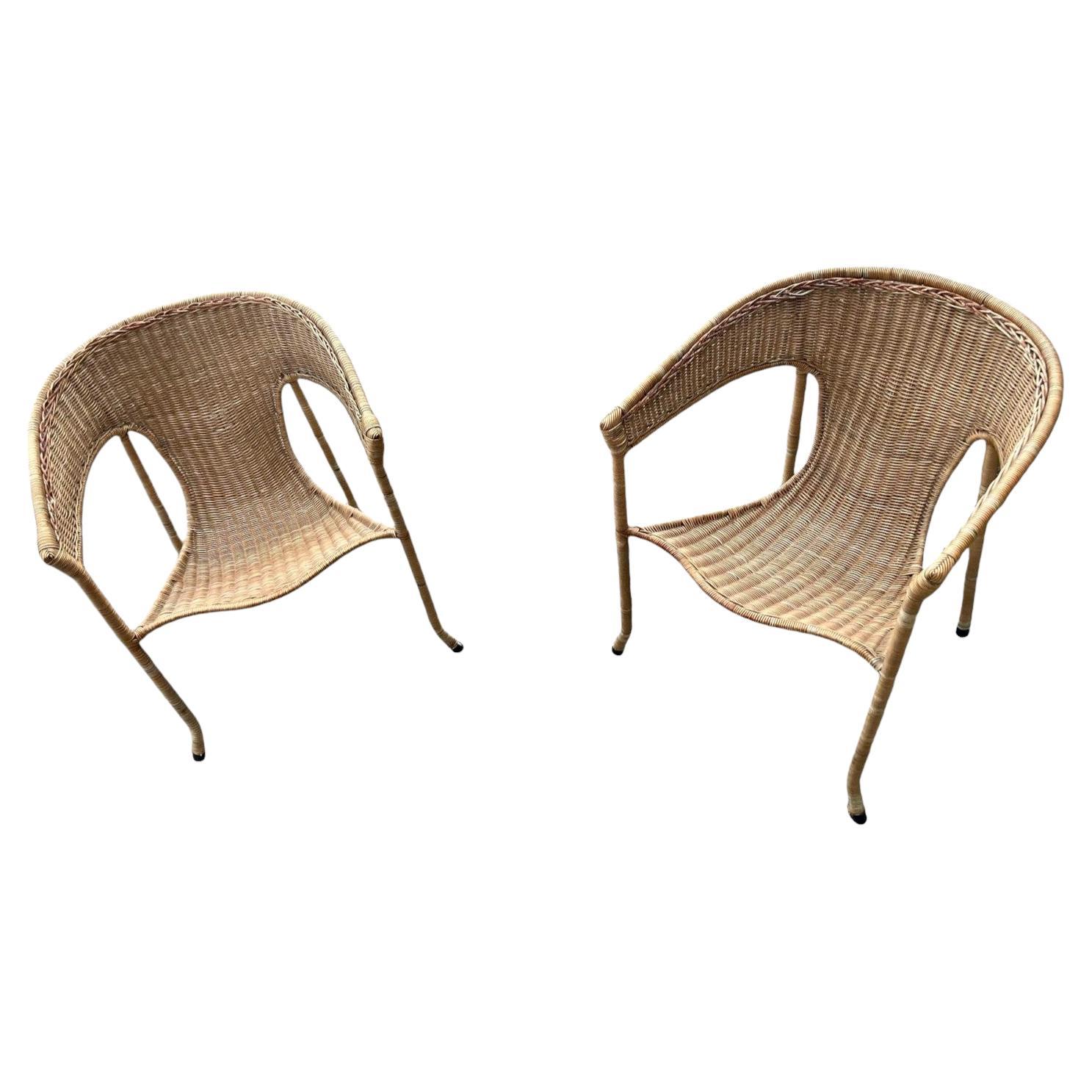 Questa splendida coppia di poltrone in vimini della metà del XX secolo, progettata dal designer californiano Francis Mair, è un'interpretazione moderna del classico artigianato in rattan. Presenta una struttura liscia e arrotondata con uno schienale