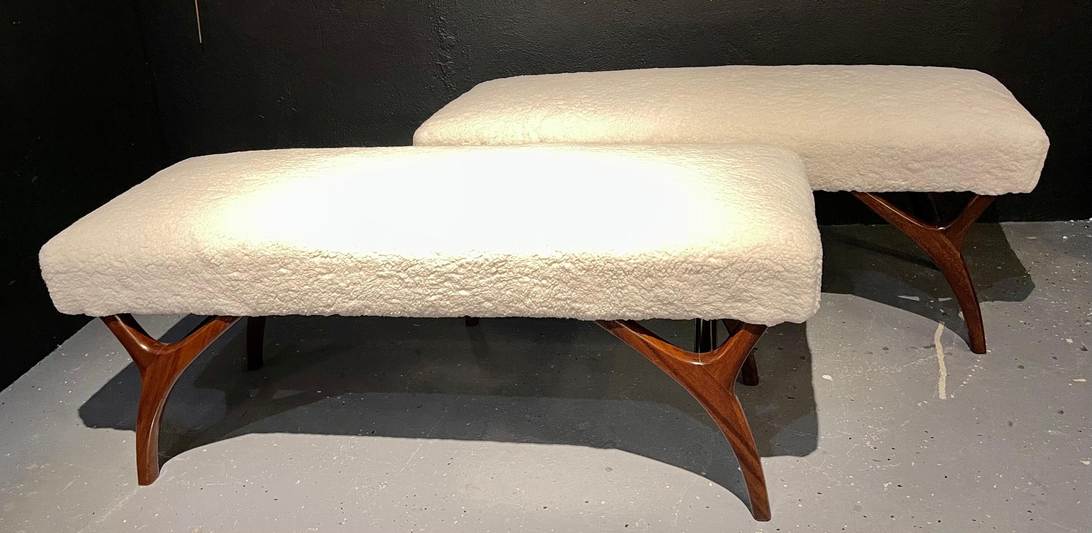 Mid-Century Modern pair of window benches or stools in new upholstery. The pair having sleek and stylish form with curved walnut legs supporting an overstuffed seat having recently been recovered.