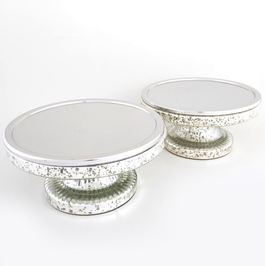 This stunning pair of Mid-Century Modern mercury glass tazza serveware pieces combines simplicity and elegance, making them a perfect addition to any table setting or décor. Each tazza features a sleek, round top resting gracefully on a sturdy round
