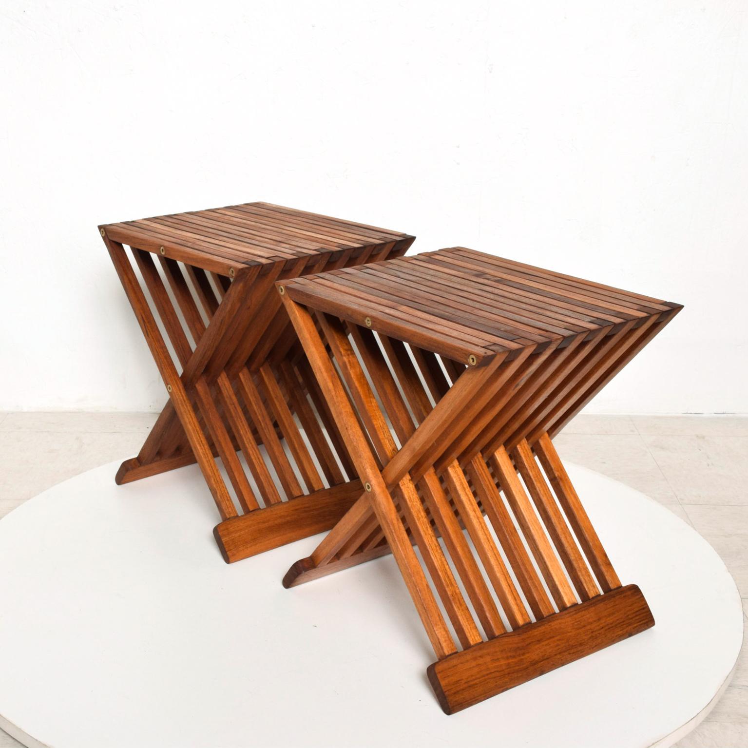 We are pleased to offer for your consideration, a pair of teak side folding tables. Unmarked. No information present on the maker. Amazing design. Tables are strong enough to be used as side chairs. Dimensions: 17 1/2