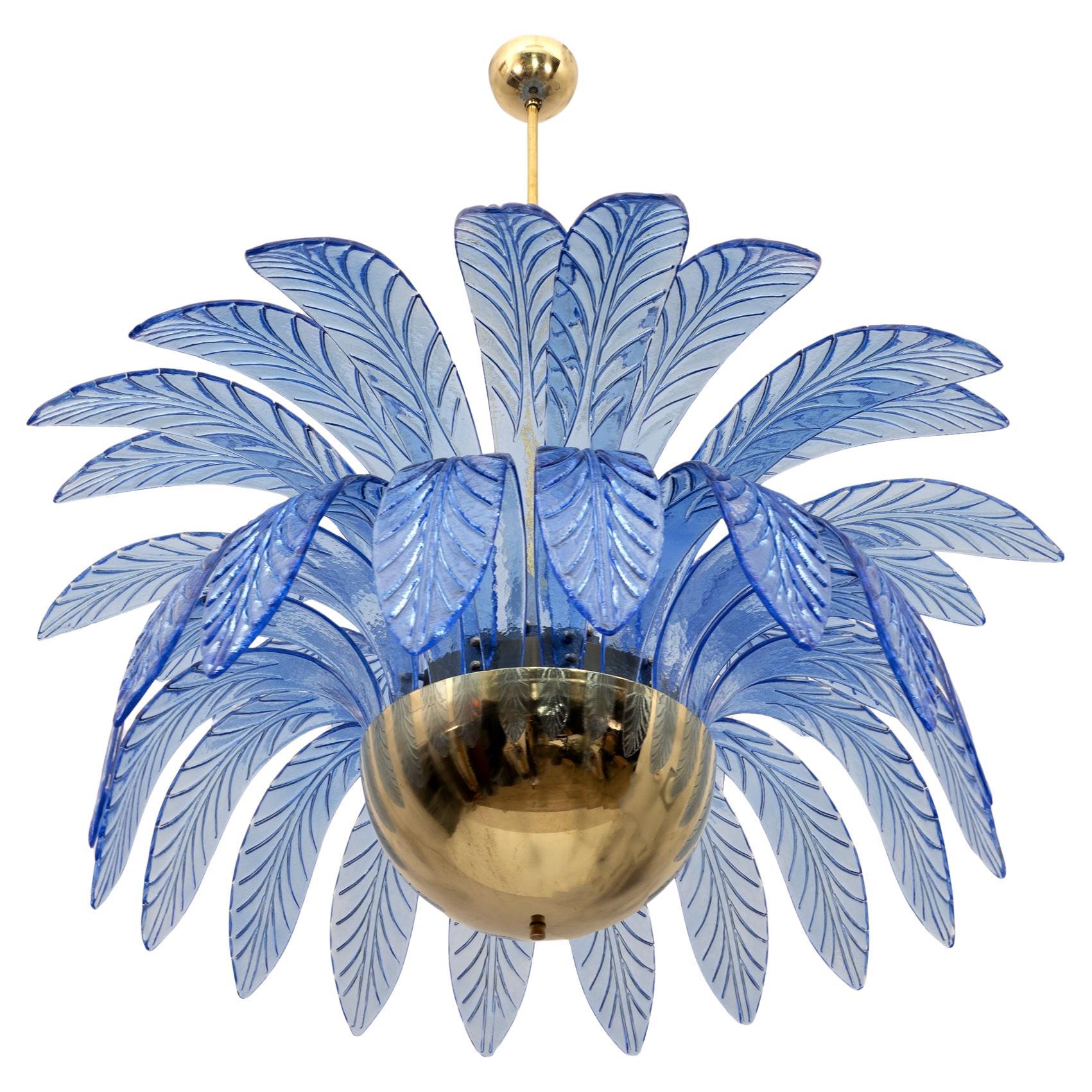 Large mouth-blown Murano glass chandelier, 38 light blue Murano glass leaves, brass structure, 12 light bulbs. The chandelier reproduces the crown of a palm tree. We supply reducers for E12 USA bulbs.
The minimum height, if you want to shorten the