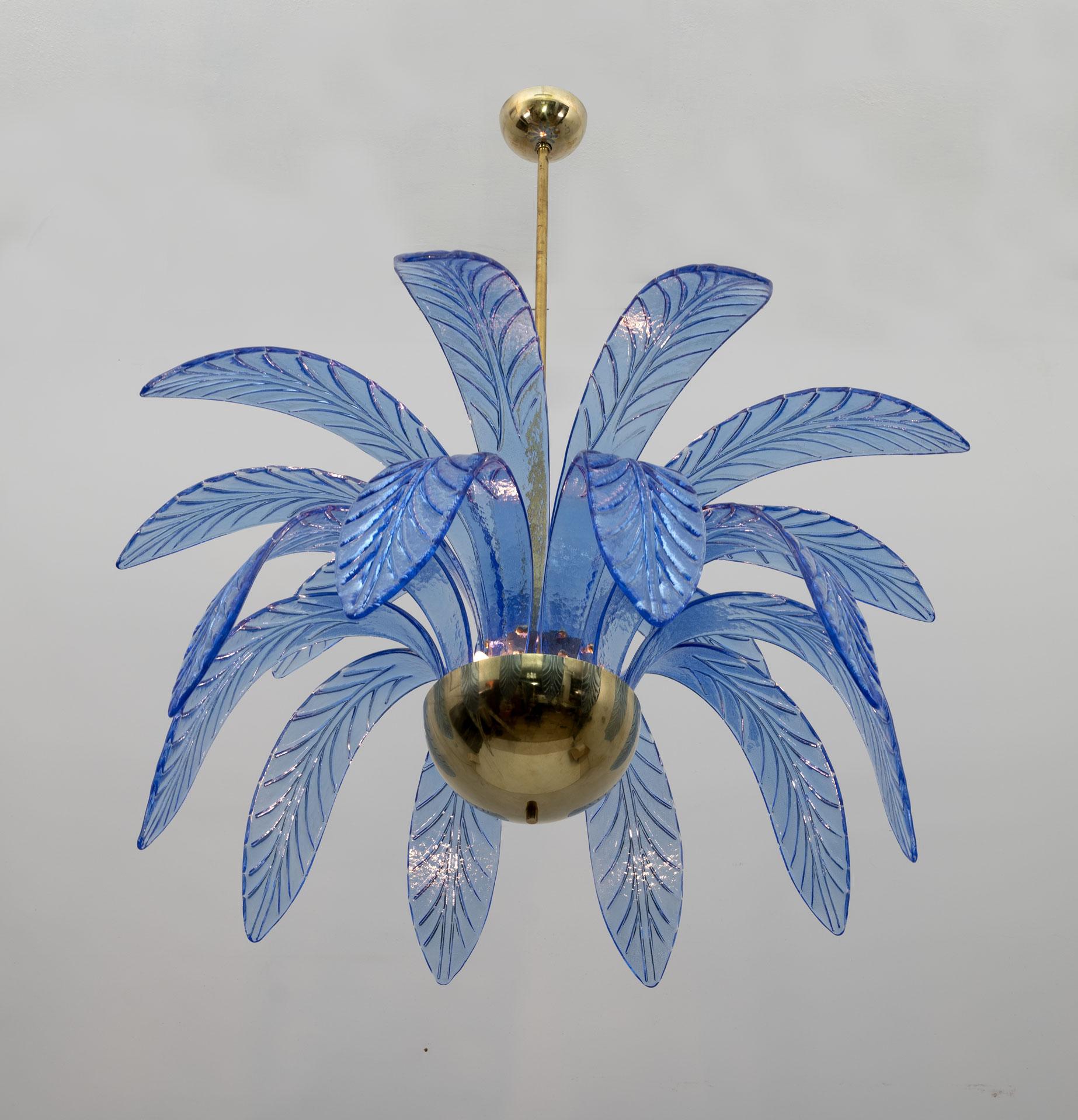 Mouth-blown Murano glass chandelier, light blue Murano glass leaves, brass structure, three light bulbs. The chandelier reproduces the crown of a palm tree. We supply reducers for E12 USA bulbs.
