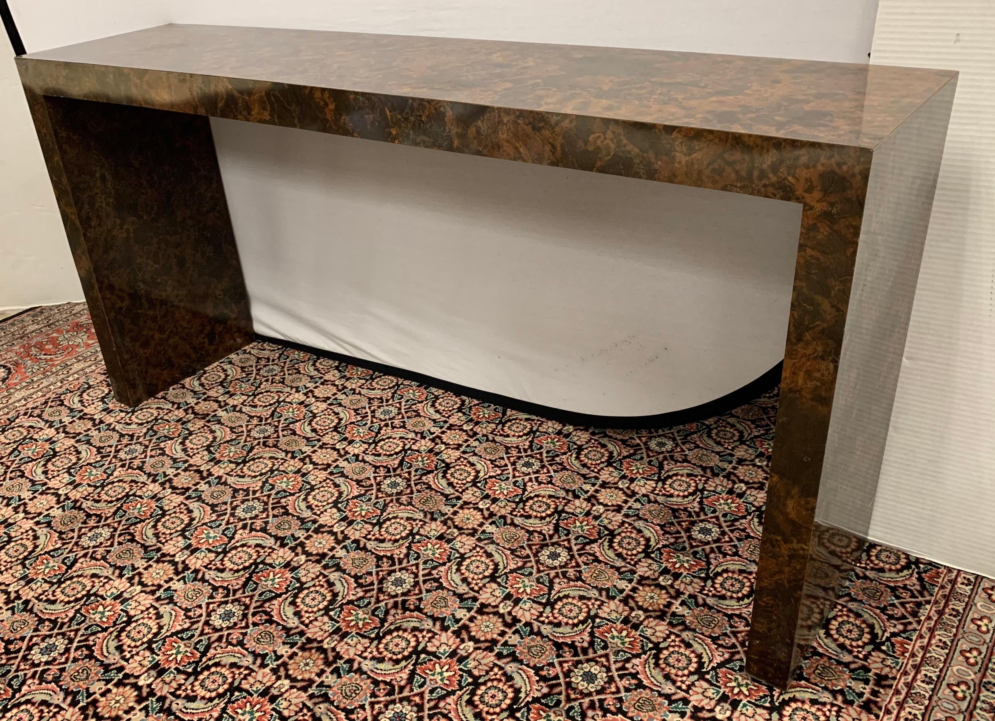 Great scale and better lines are evident in this midcentury parsons console table that features a burl tortoise laminate and is in great condition. A true statement piece. Now, more than ever, home is where the heart is. Measure: Five feet.