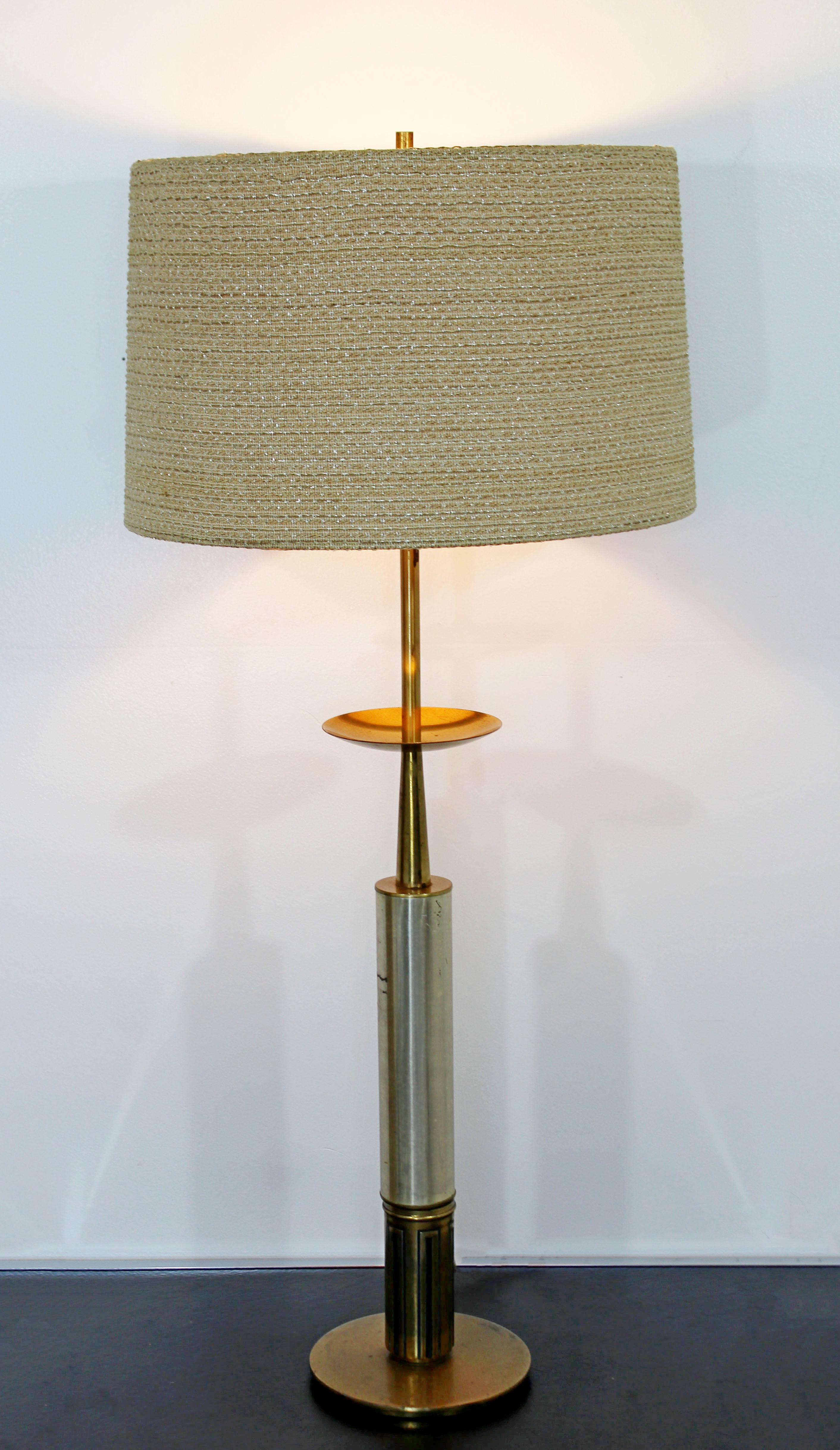For your consideration is a fabulous, brass and silver plated table lamp, with original shade and finial, in the style of Tommi Parzinger, circa the 1960s. In good condition. The dimensions of the lamp are 8