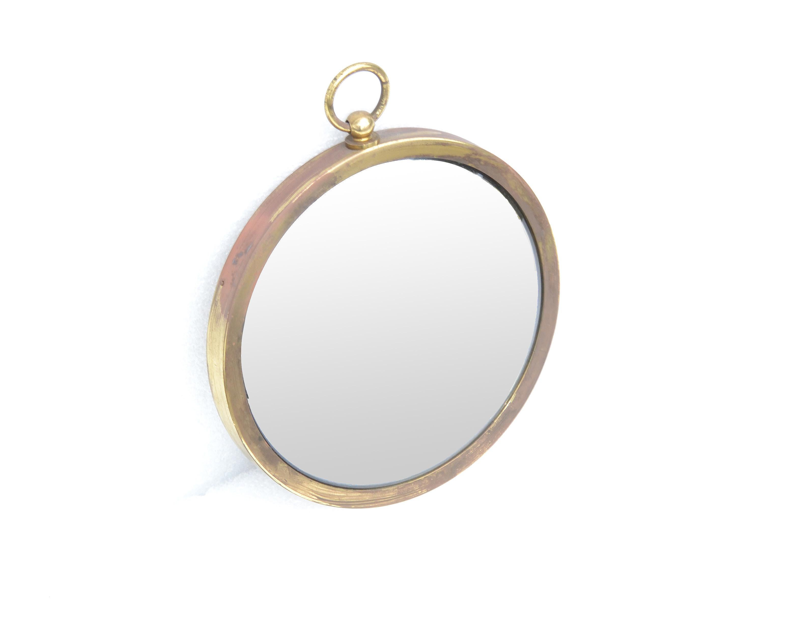 Jacque Adnet style French Mid-Century Modern wall convex mirror in patinated brass pocket watch shape.
Made in France in the late 1960s.
Can be polished & lacquered when desired a perfect look.
Round mirror glass measures 7.25 inches diameter.