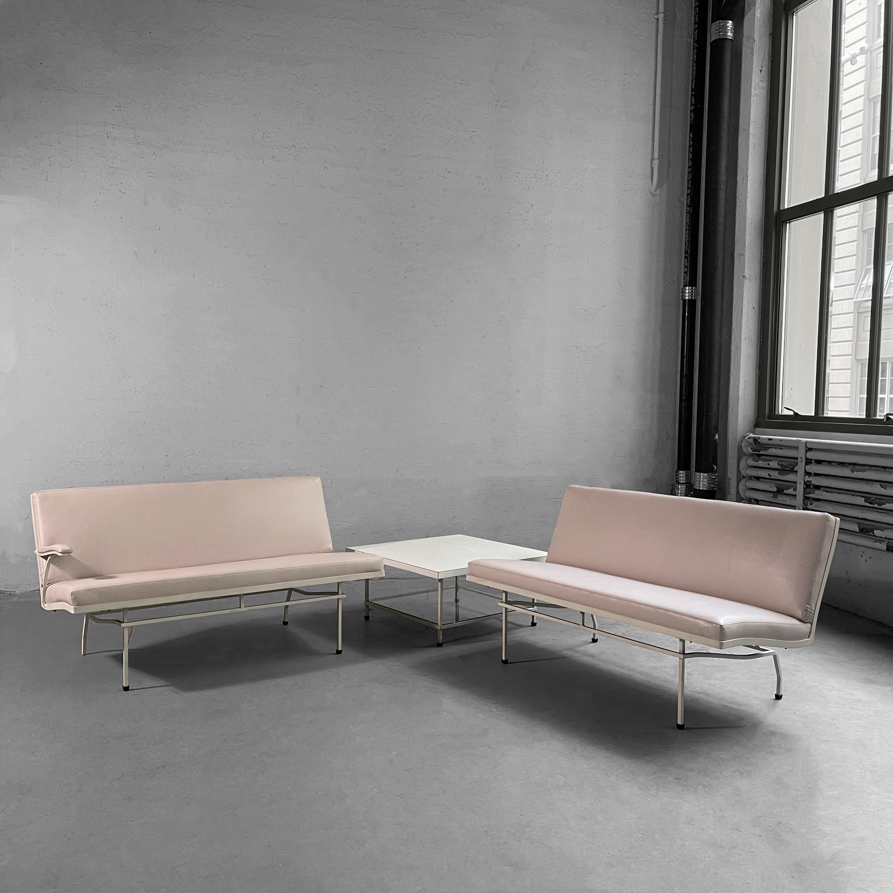 Mid-Century Modern, 3 piece, patio seating set by Lee L Woodard Sons features two, painted wrought iron, 3 seat sofas upholstered in pale pink textured outdoor vinyl with matching, wrought iron, tiered side table with formica top and glass shelf at