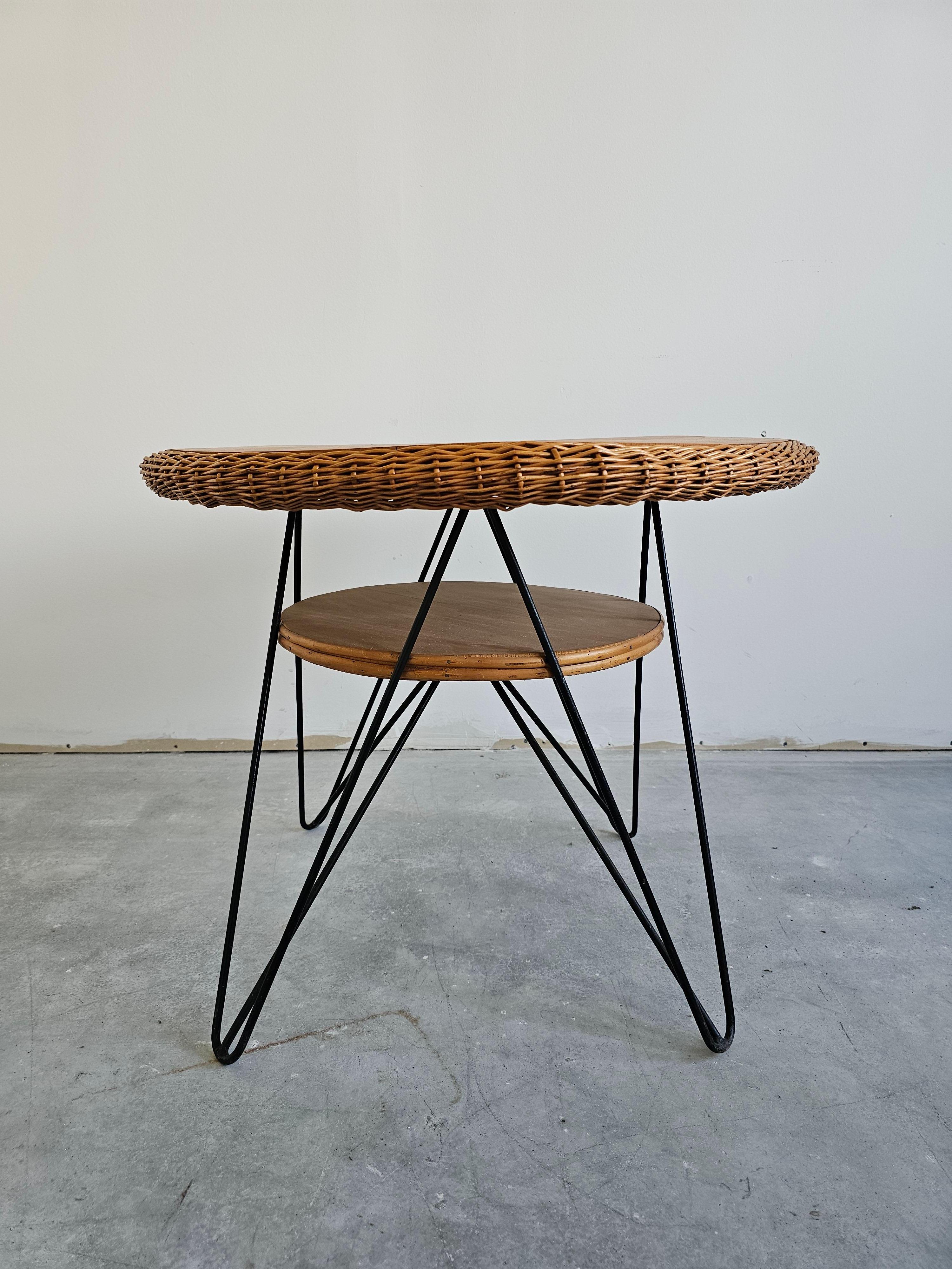 In questa inserzione troverai uno splendido tavolo da patio moderno del Mid Century. Il piano in vimini e legno è fissato alle gambe in ferro verniciato nero. Realizzato in Italia negli anni '50.

Buone condizioni vintage con alcuni segni del tempo