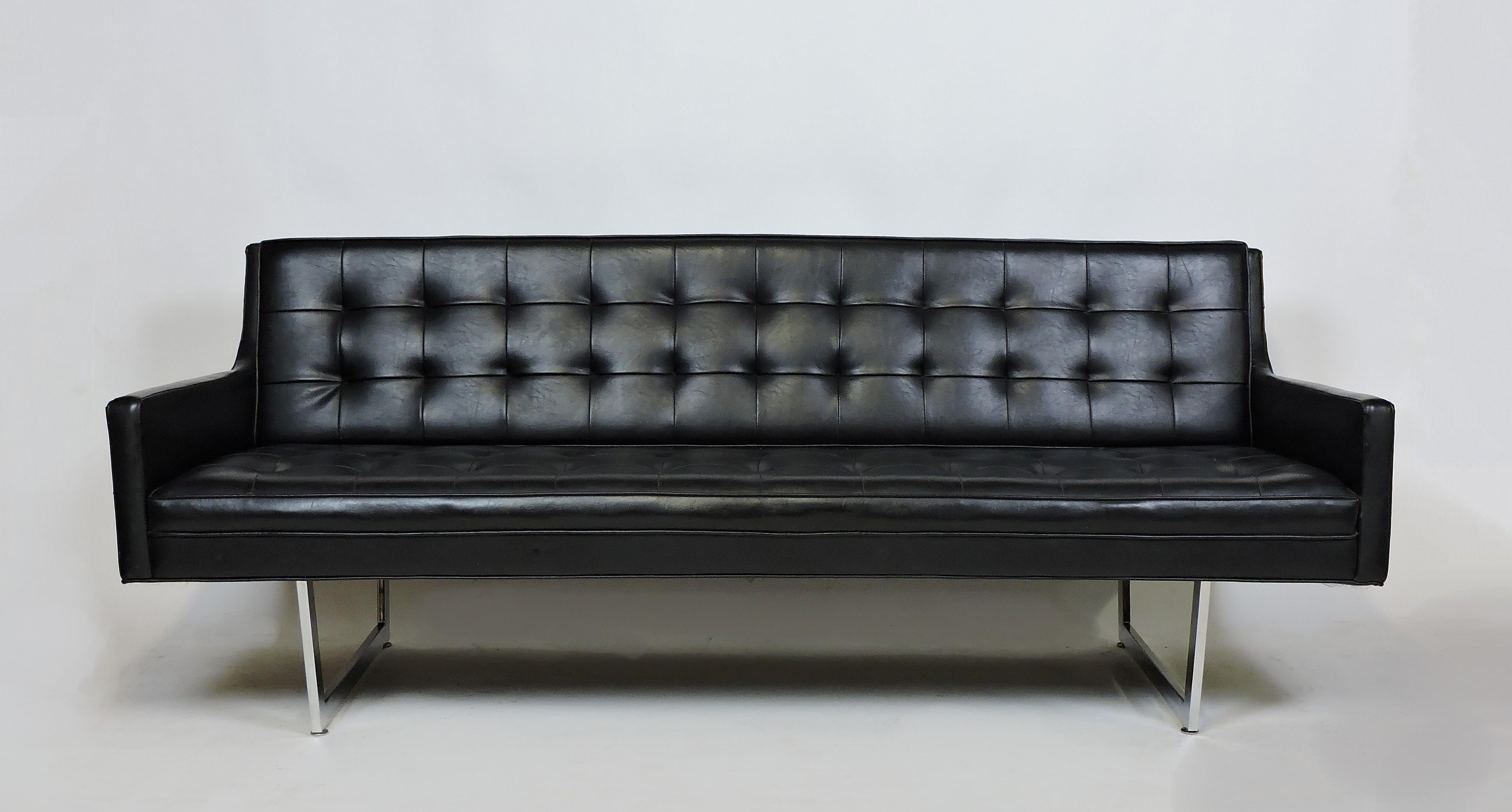 Sleek and Minimalist styled sofa manufactured by high quality furniture maker, Patrician Furniture Company. This sofa has tufted black Naugahyde upholstery and rests on a thin chrome sled base. Comfortable and sturdy with a great clean, modern