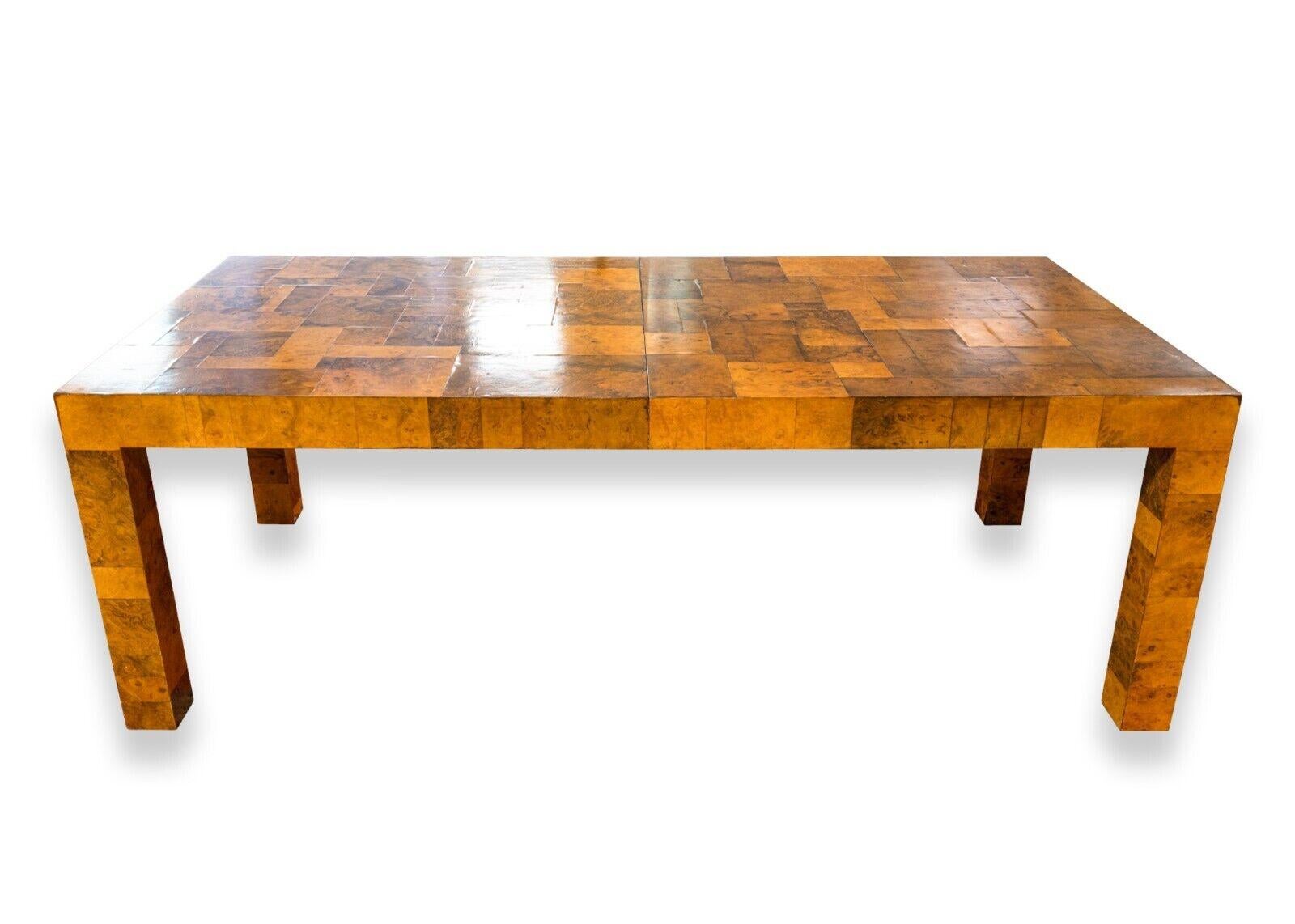 A mid century modern Paul Evans signed burlwood patchwork expandable dining table. This is a jaw-droppingly gorgeous table from Paul Evans featuring one of his many iconic designs. This piece features a lovely burlwood patchwork design. The burlwood