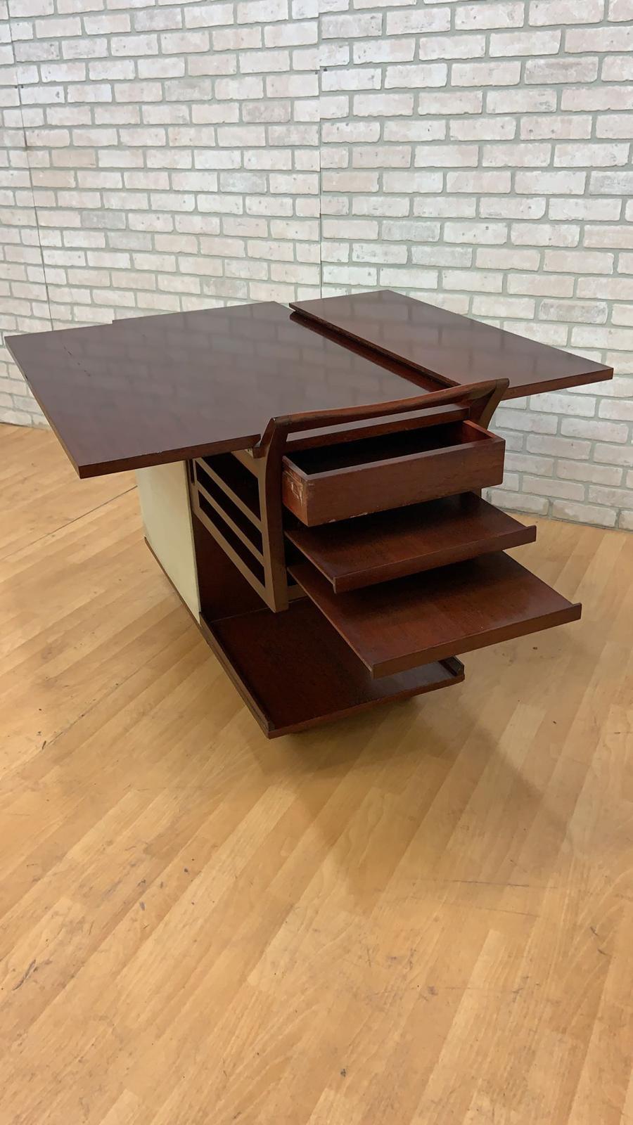 Mid-Century Modern Paul Frankl Expanding Serving Cart

Super cool and rate vintage mahogany Paul Frankl serving/bar cart. One side has a drawer and 2 pullout shelves. The other side has a door that opens up to a compartment with 2 shelves. The top