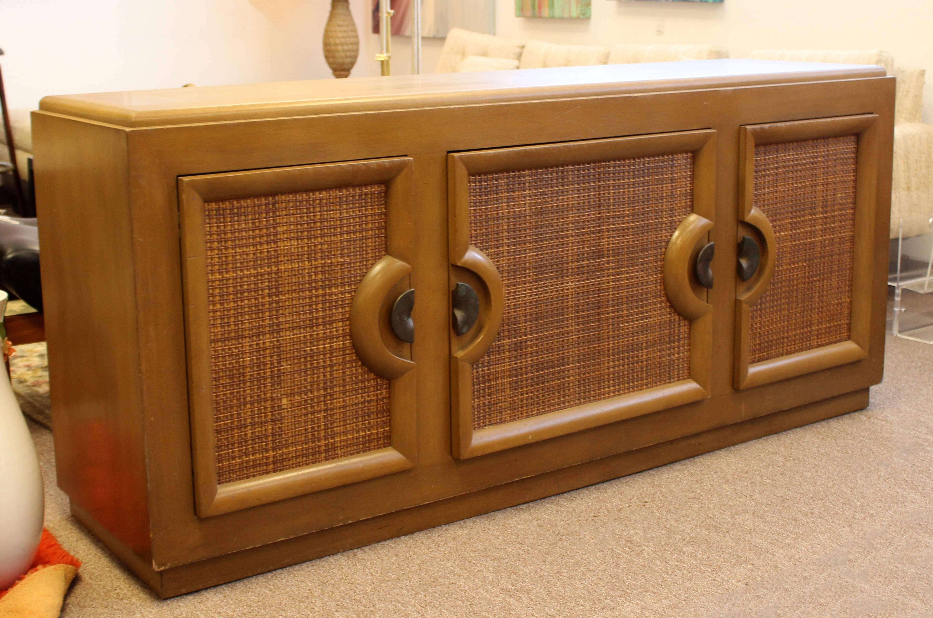 For your consideration is a phenomenal, wood and cane credenza, with three doors and four drawers, Paul Laszlo for Brown Saltman, circa 1950s. In great condition. The dimensions are 72