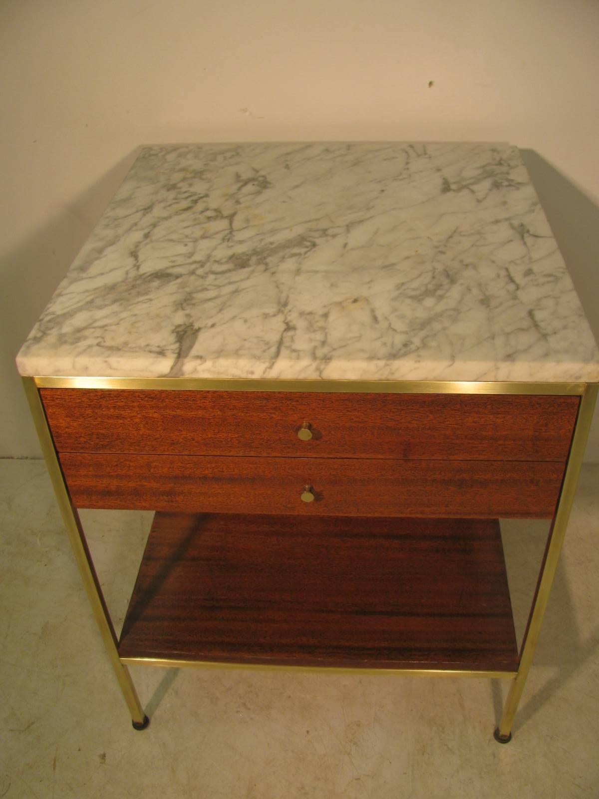 Simple and elegant night table by Paul McCobb for Calvin. Brass frame which supports the mahogany frame two drawers and shelf below. Marble top is Italian Carrara marble original to the piece. Recently refinished and brass polished.