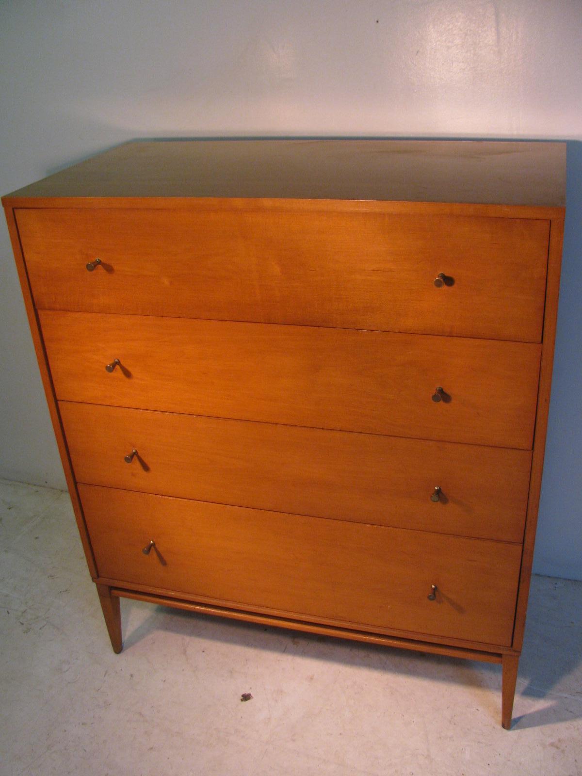 Simple and elegant 4-drawer dresser by Paul McCobb. Signature hour glass pulls with a large drawer at the bottom all in Birch. Very tight well constructed piece, signed on top drawer. In excellent vintage condition with minimal wear 
