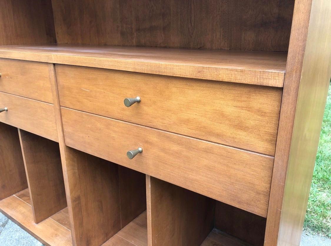 1950s authentic Paul McCobb Planner Group modular bookcase. Made of heavily constructed maple
wood and features gorgeous color and wood grain construction. There is ample storage throughout including two drawers with brass pulls. The piece is in