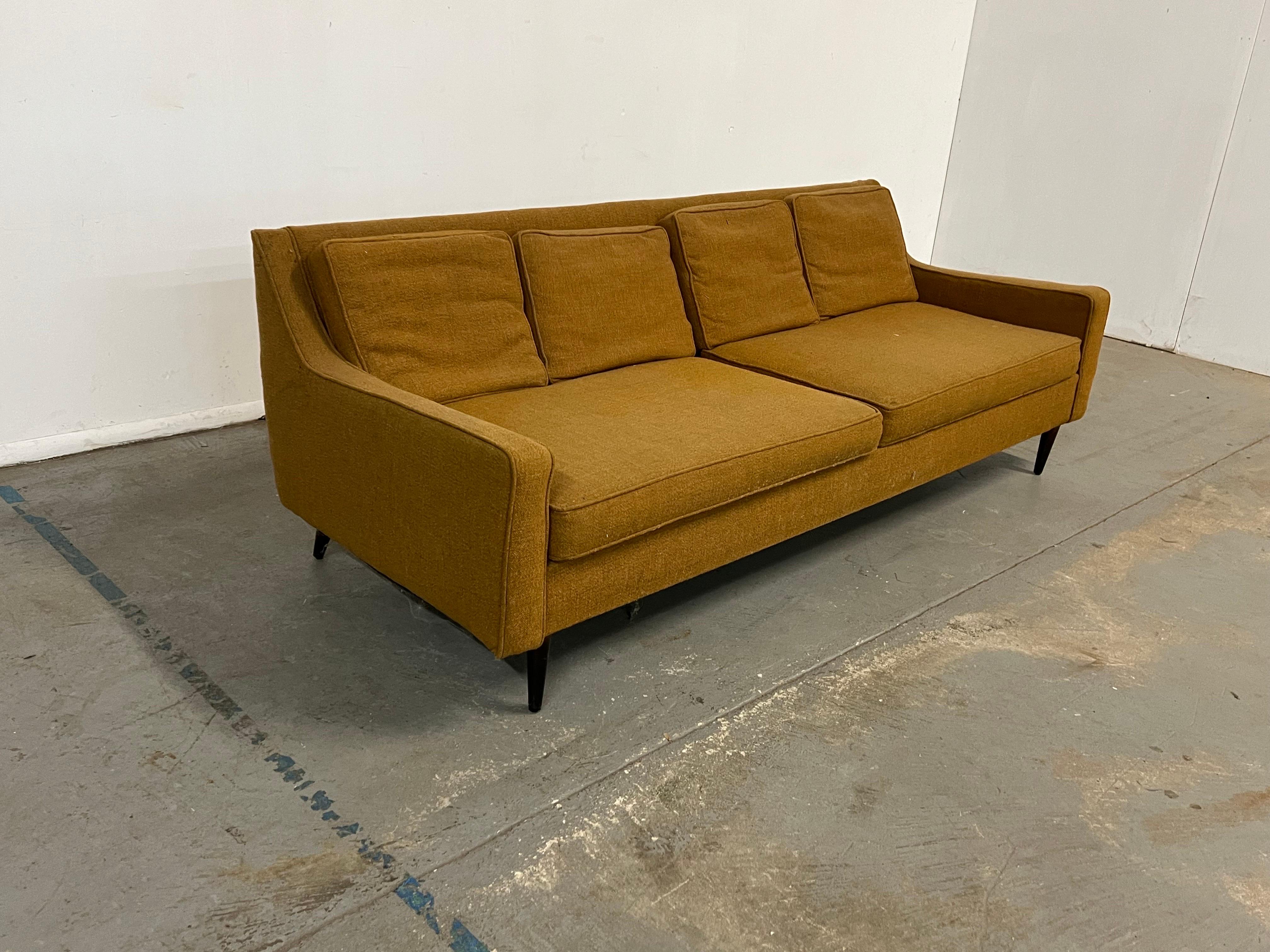 Mid-Century Modern Paul McCobb style sofa on pencil legs

Offered is an unrestored Mid-Century Modern sofa in the style of Paul McCobb. The sofa  has sharp and curved lines which make it  unique. The pencil legs elevate and give the floating