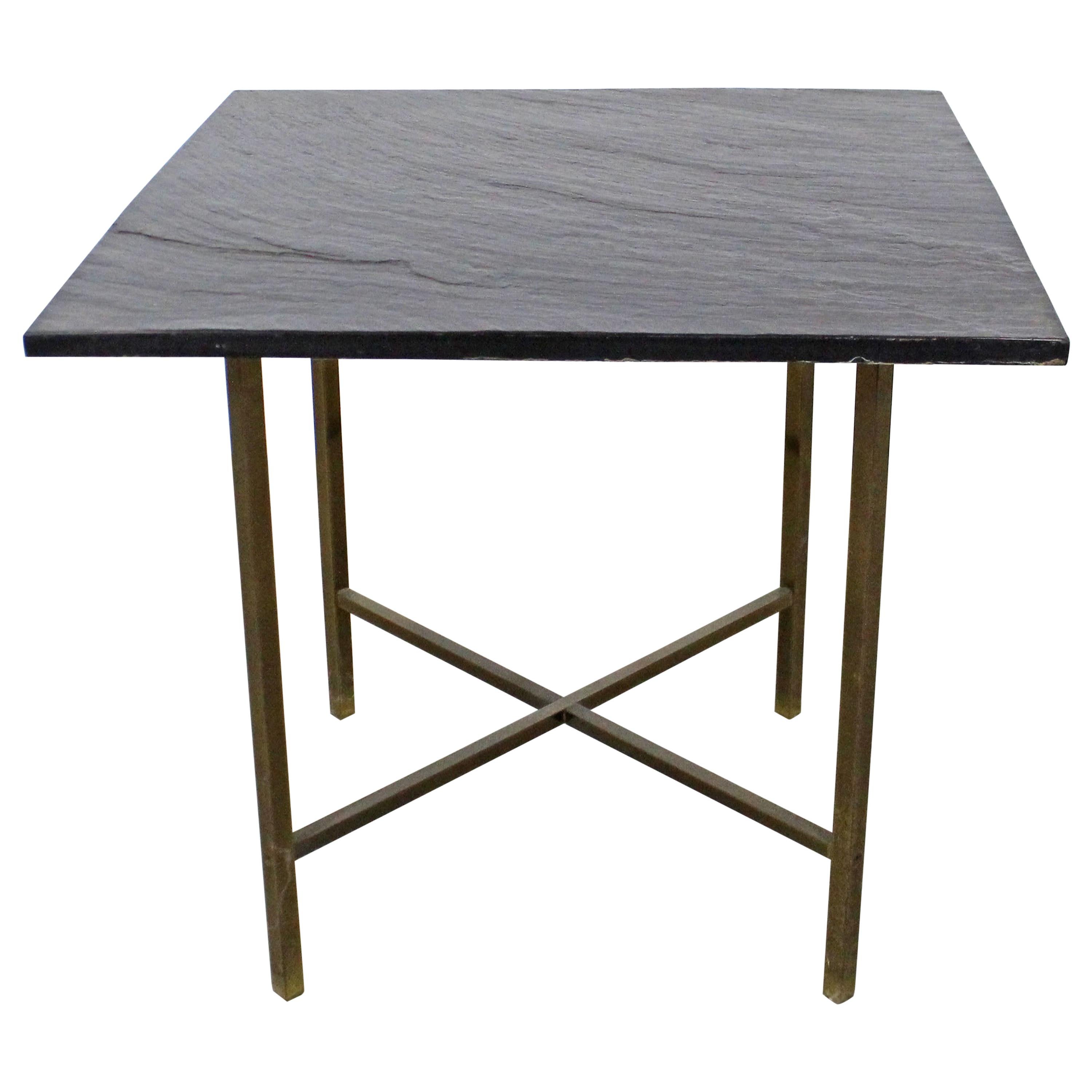 Cette table d'appoint vintage de style Mid-Century Modern est dotée d'un plateau en ardoise amovible et d'une base en laiton en forme de X. Elle est en bon état avec une légère usure due à l'âge, notamment une usure superficielle de l'ardoise ainsi