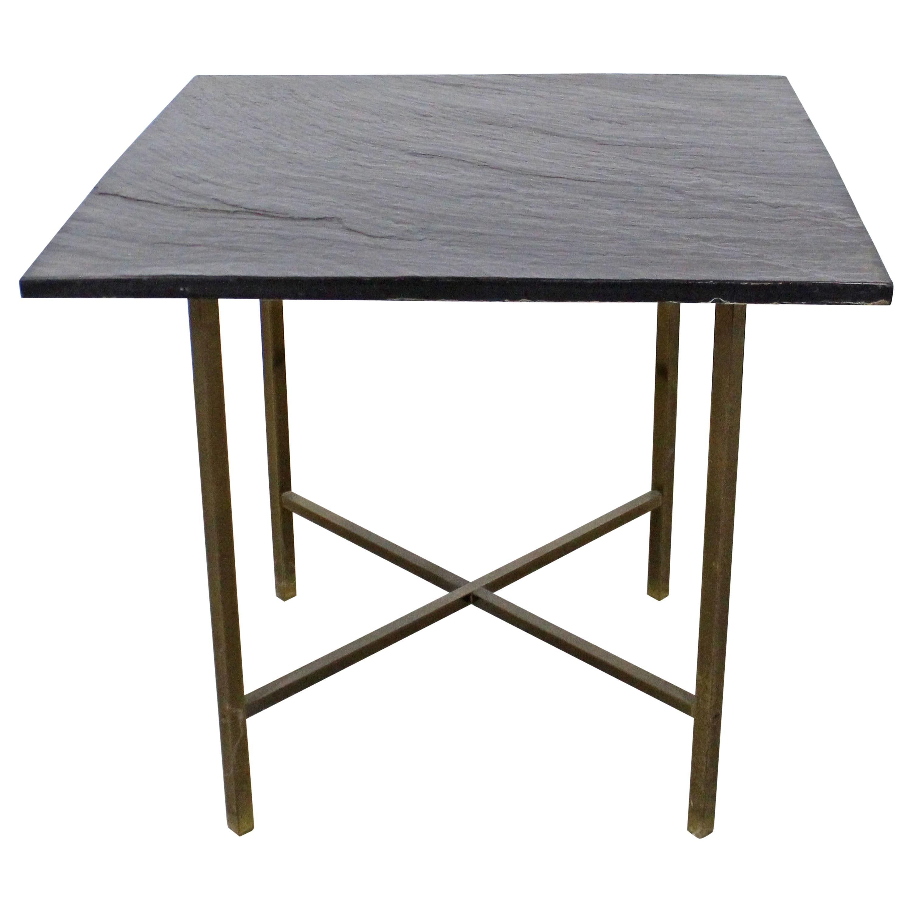 Offered is a Mid-Century Modern style vintage end table with a removable slate-top and an X-shaped brass base It is in good condition with some slight age wear including surface wear on the slate as well as some wear and patina on the brass. The