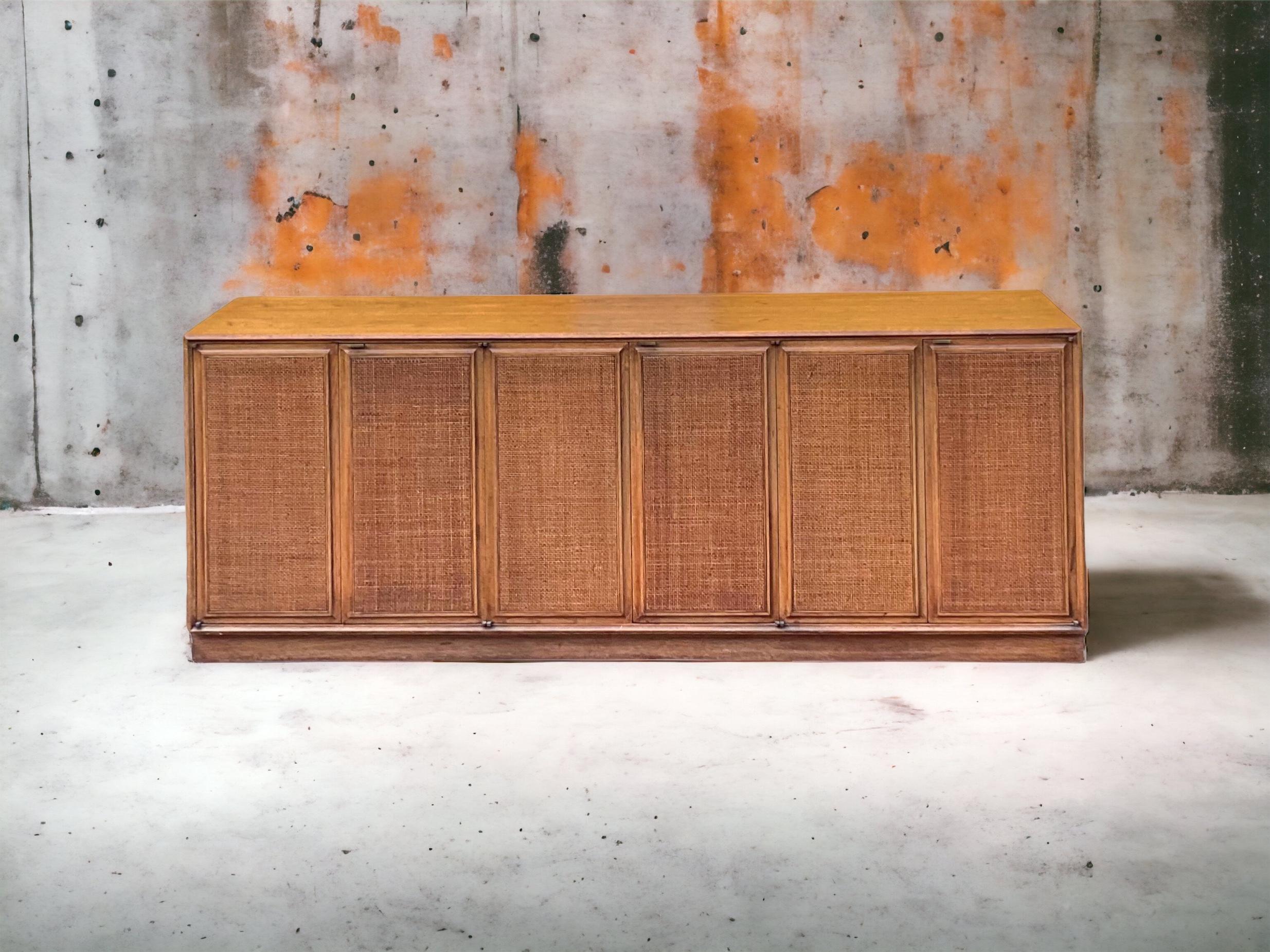 I love this hard-to-find cane front Paul McCobb credenza! The frame appears to be oak, and the six panels open to drawers over shelves. It dates approximately to the 1960s. It is unmarked.
