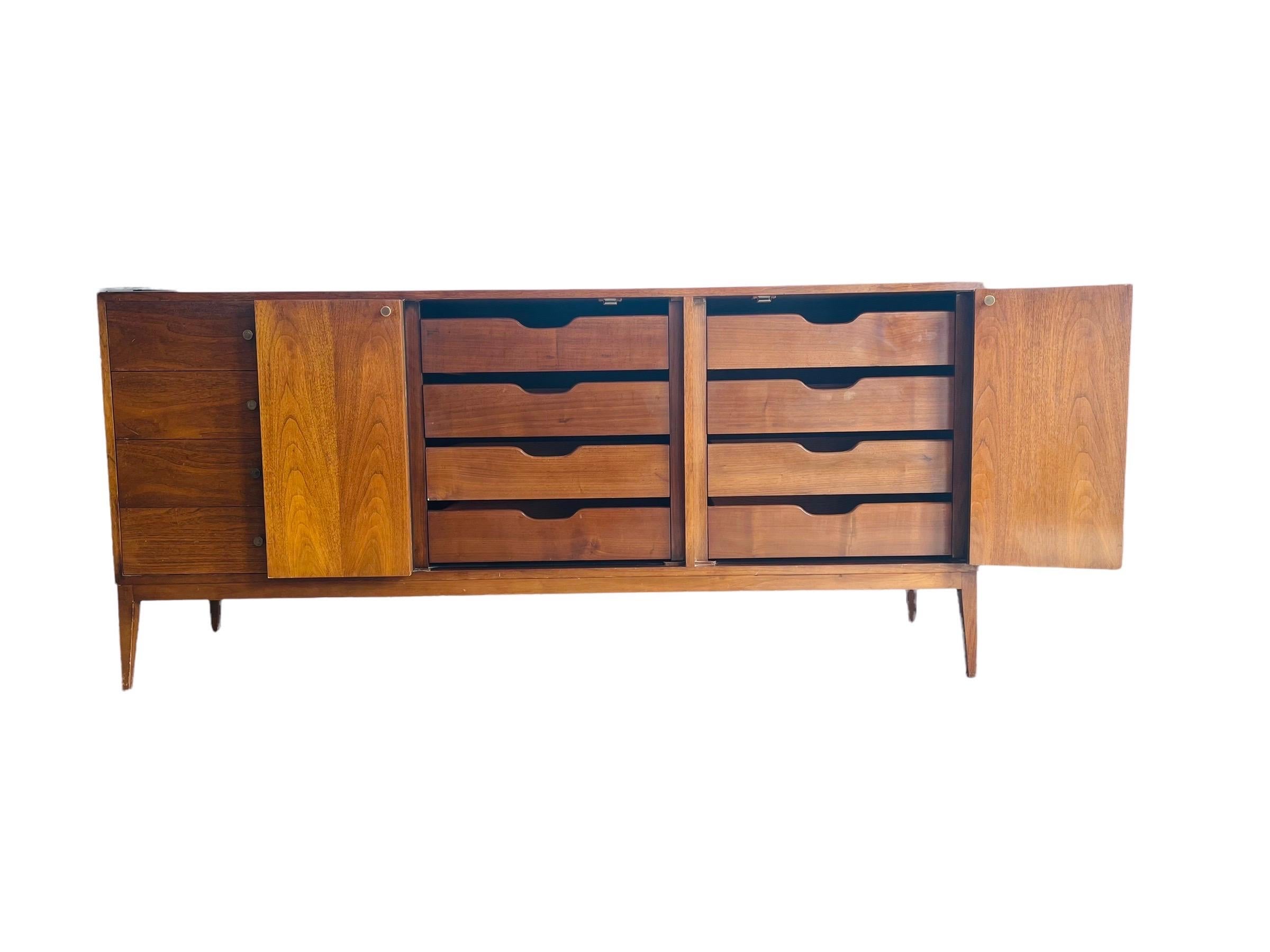 Stunning Mid-Century Modern Paul McCobb style Walnut Triple dresser in great vintage condition with normal wear consistent with age and use. This dresser is equipped with 12 drawers, with 8 drawers being behind the folding doors. 

Measures: W 72”