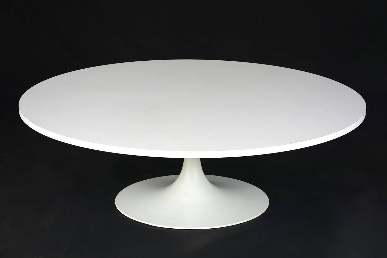 This 1960s Mid-Century Modern oval coffee table or cocktail table features a formica covered wood top with a metal base. The table is finished in a stark white color that will stand out in any room. This coffee table is sturdy, sleek, and ready to