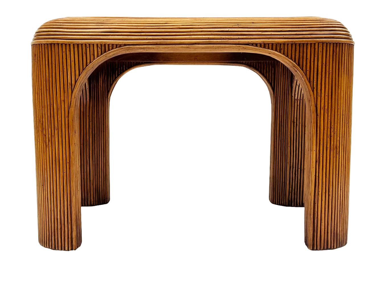 A gorgeous set of rattan bamboo side or drink tables from the 1980's. It features a well built stunning form with glass tops. Price includes the pair. 