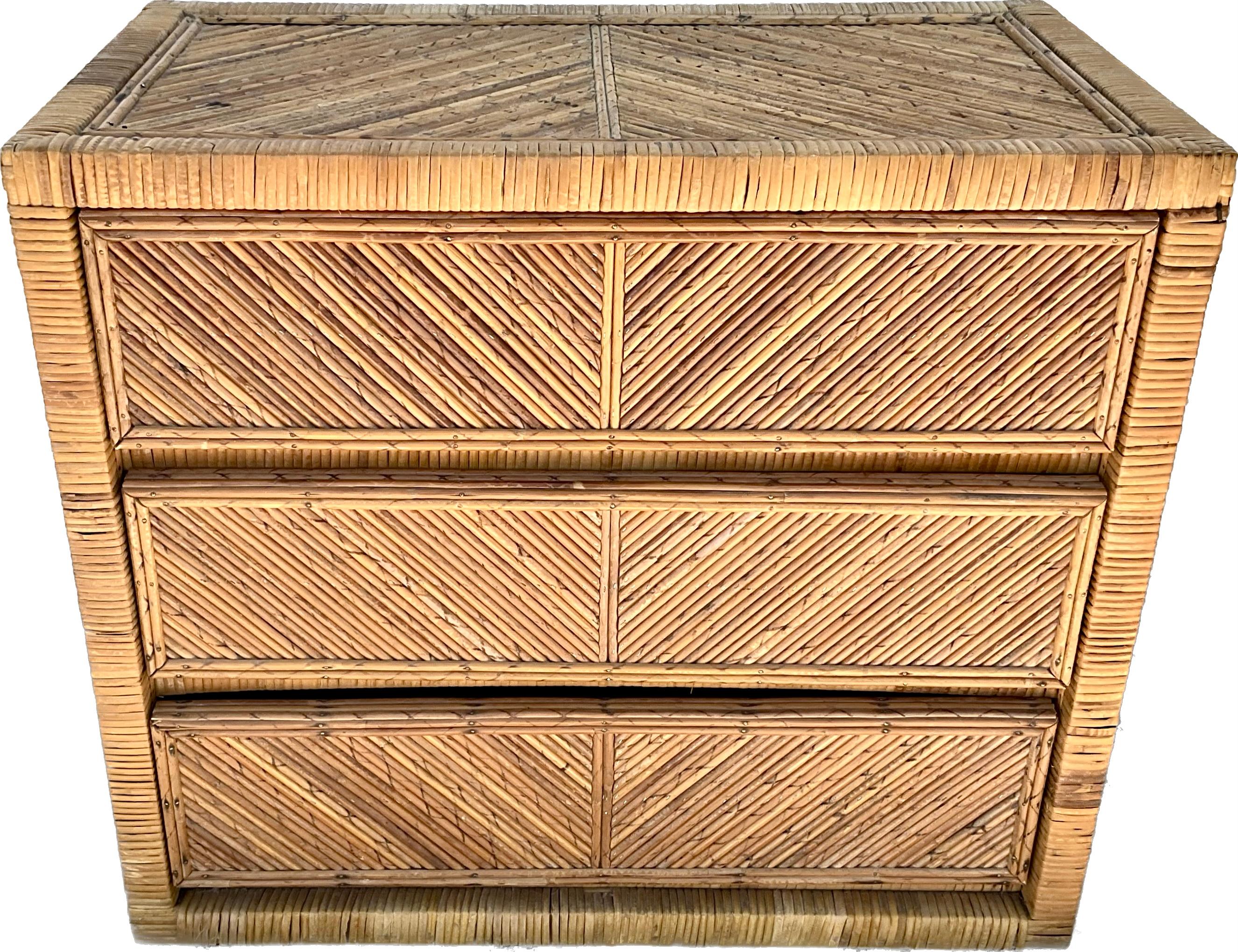 Mid-century modern pencil reed rattan chest.  The pencil reed provides a unique geometric pattern on drawer fronts. Chest has three large drawers and rattan is finished on all sides. Large drawers that are easy to open with hidden pulls and great