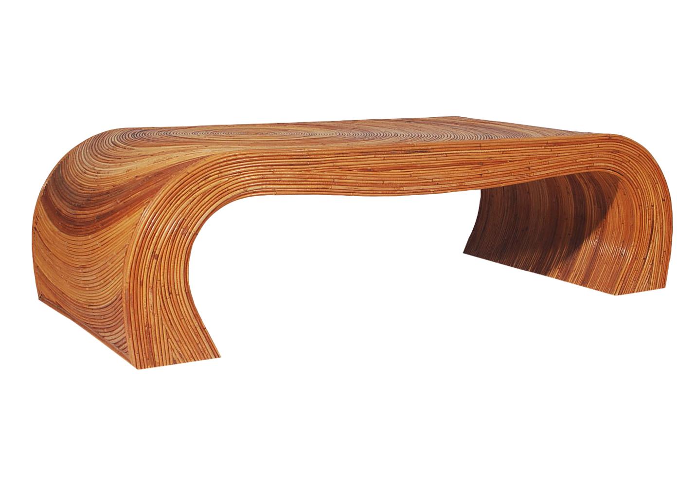 A sculptural pencil reed coffee table. It features wood construction with pencil reed bamboo design work.