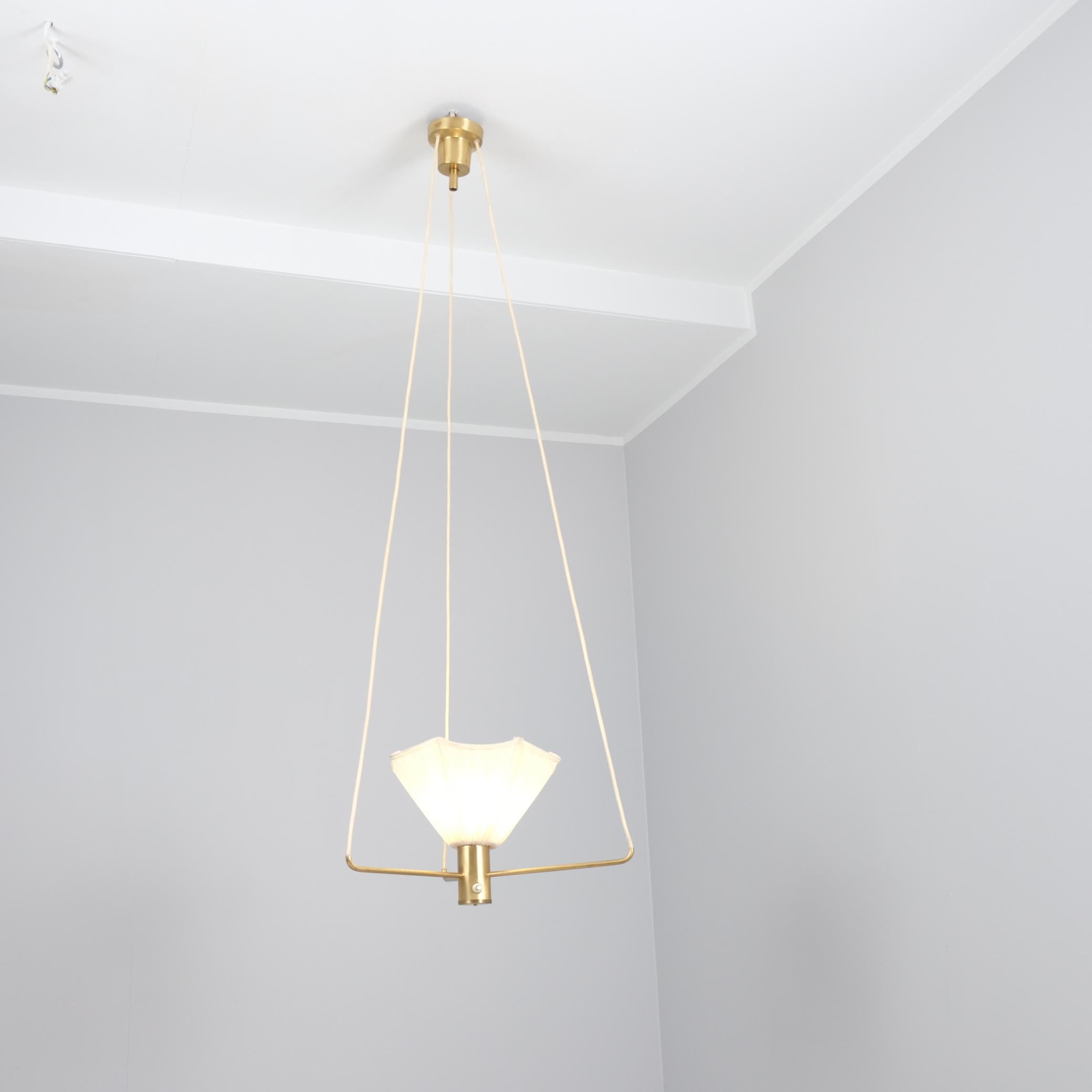 Suspension minimaliste du milieu du siècle, avec un élément central en laiton qui soutient un abat-jour en forme de fleur, suspendu par trois fils. Cette pièce fournit une lumière douce vers le haut, idéale pour créer une ambiance dans les espaces