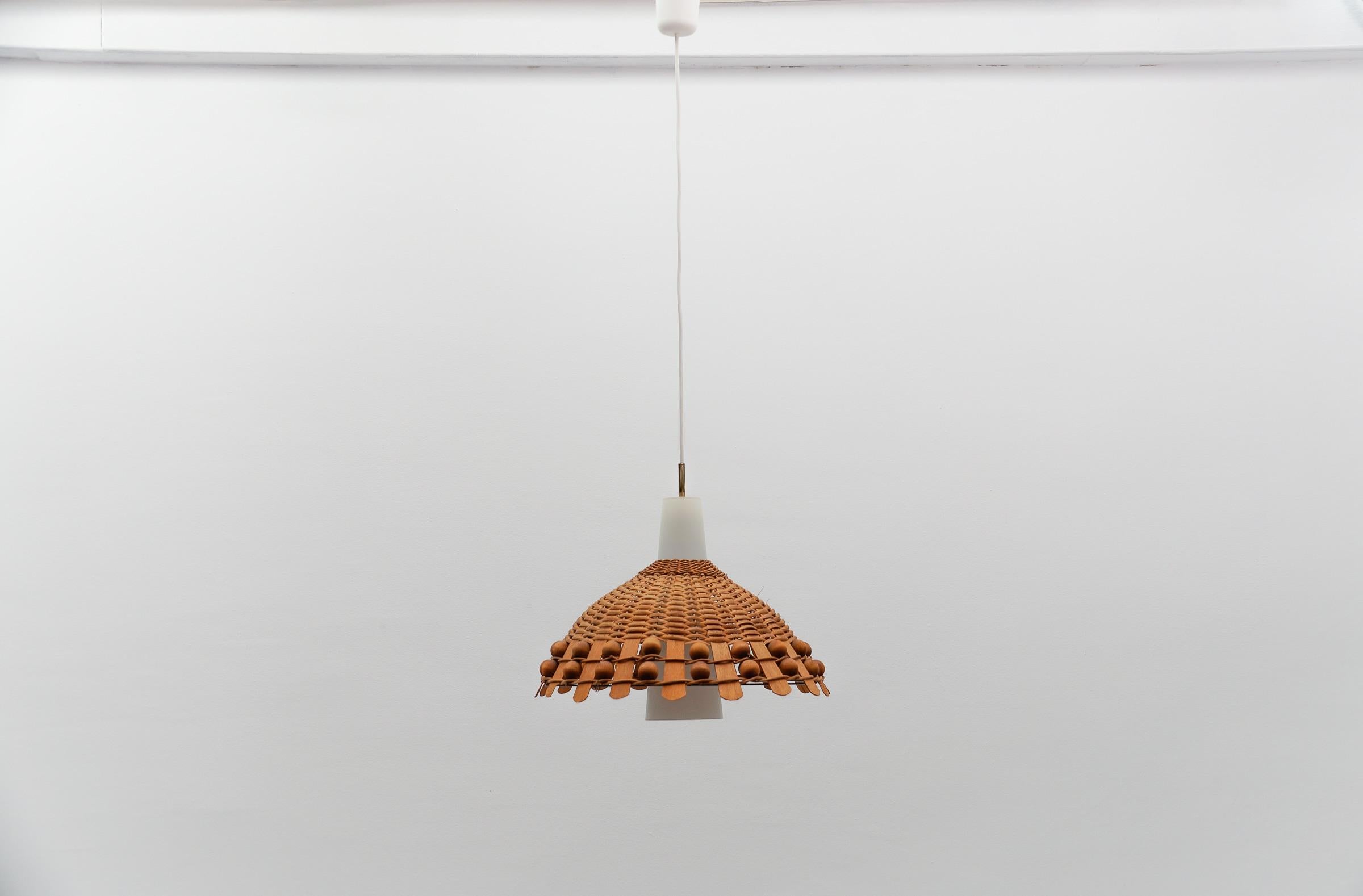 Seltene und schöne dekorative Mid-Century Modern Pendelleuchte. 

Höhenverstellbar von ca. 55cm bis 100cm.

Ausgeführt in Rattan, Opalglas und Kupfer. Die Hängelampe wird mit 1 x E27 / E26 Edison Schraubfassung geliefert, ist verkabelt und in