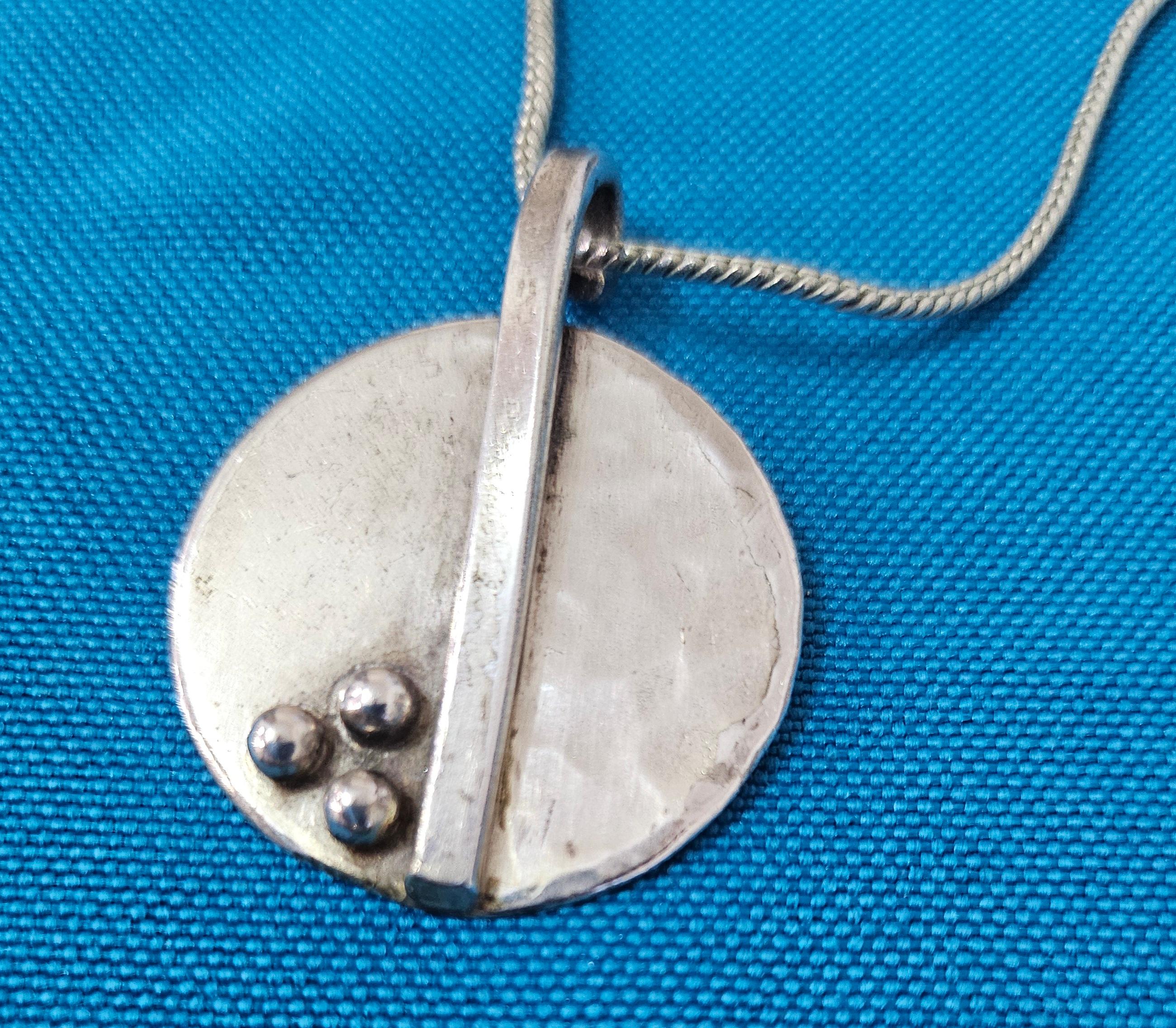 Moderne Anhänger-Halskette aus der Jahrhundertmitte mit dreidimensionalen und gehämmerten Elementen.
Diese Anhänger-Halskette aus Sterling-Metall gefällt uns sehr gut. Da sie jedoch nicht gestempelt ist, müssen wir davon ausgehen, dass es sich nicht